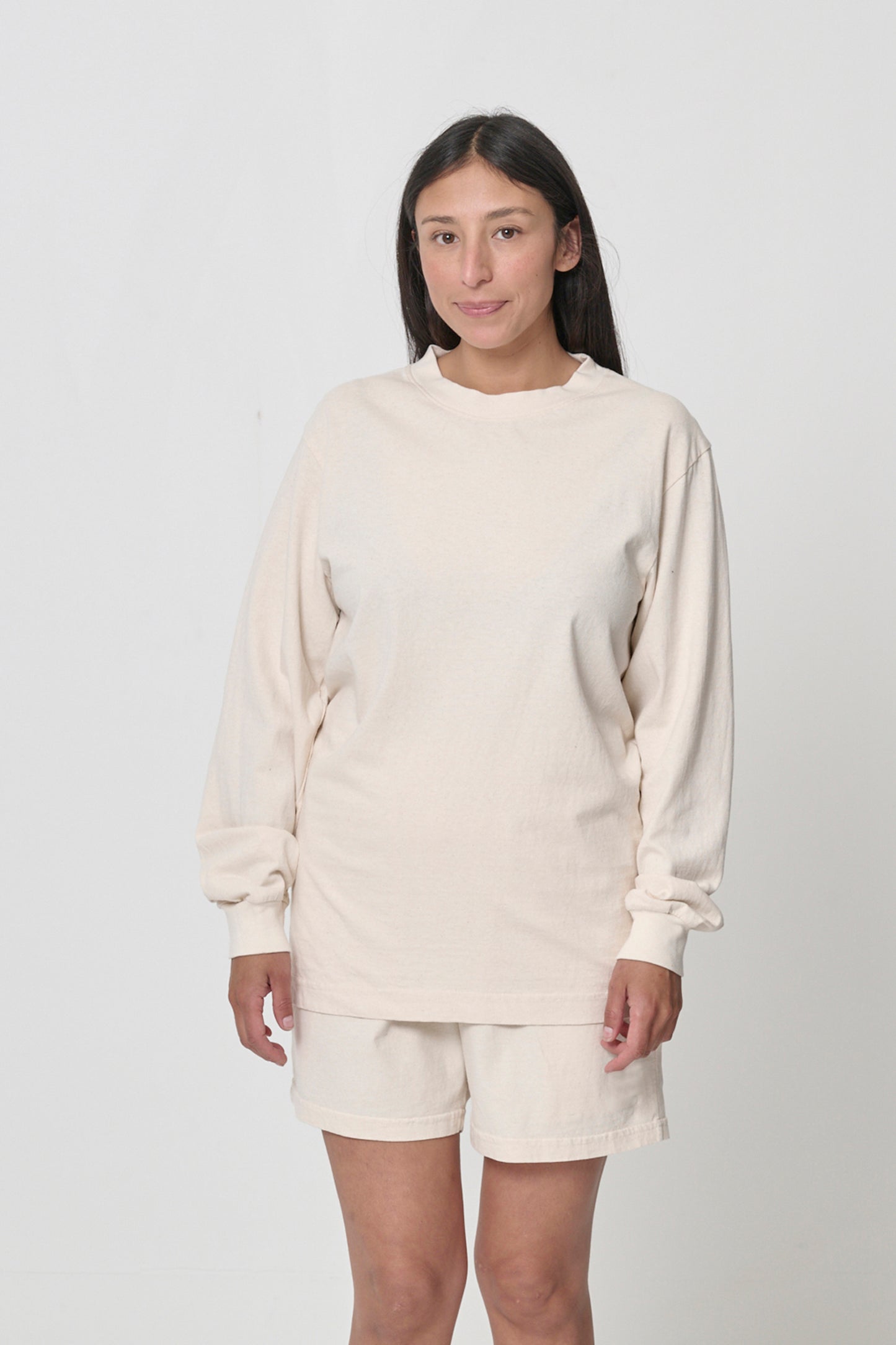 5'4" woman in size S Scour Long Sleeve Trash Tee, arms at sides, hem just below her hip.