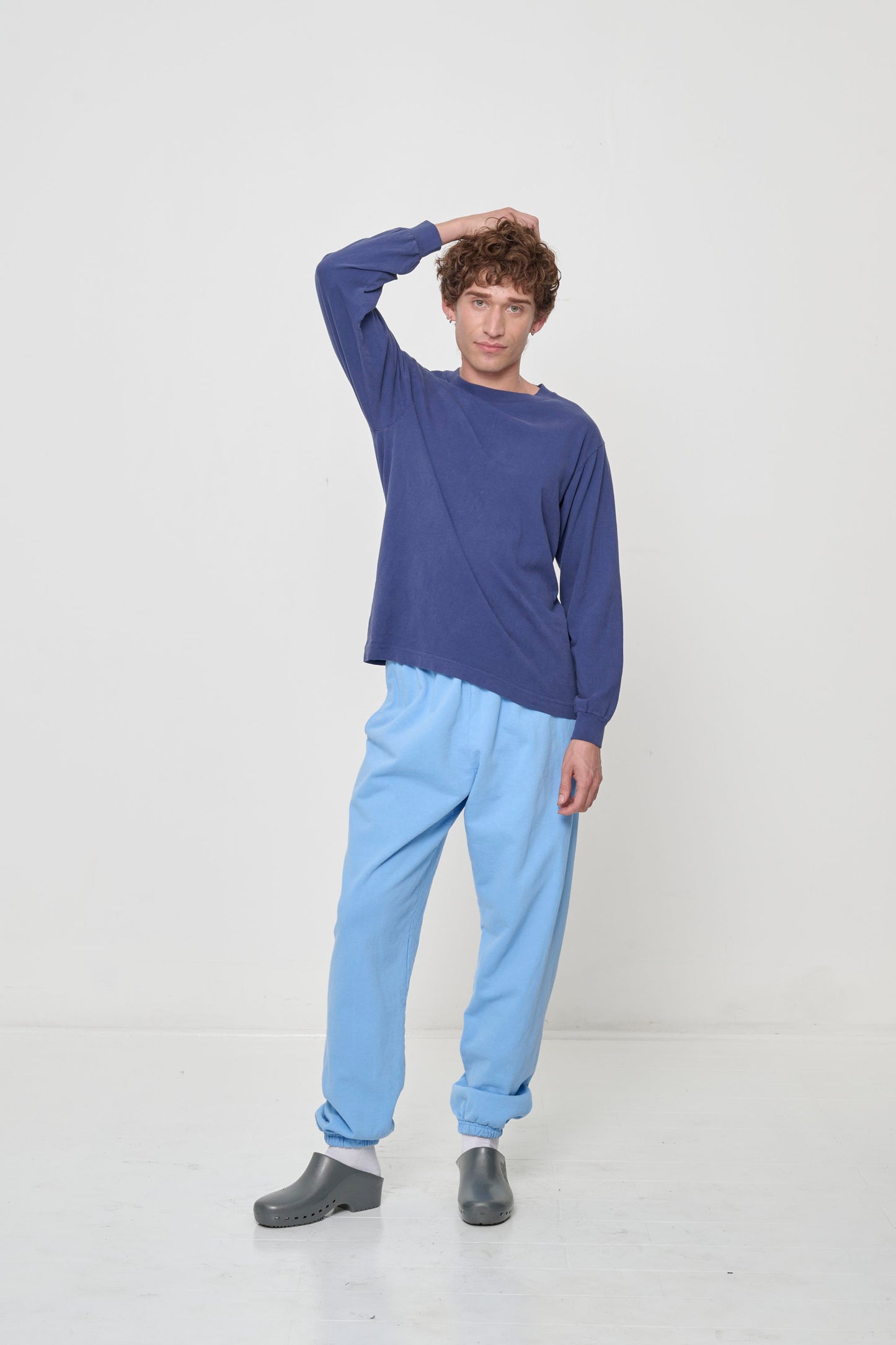 Full-length shot of a person in a Washed Navy Long Sleeve Trash Tee, hand raised to show ease of movement.