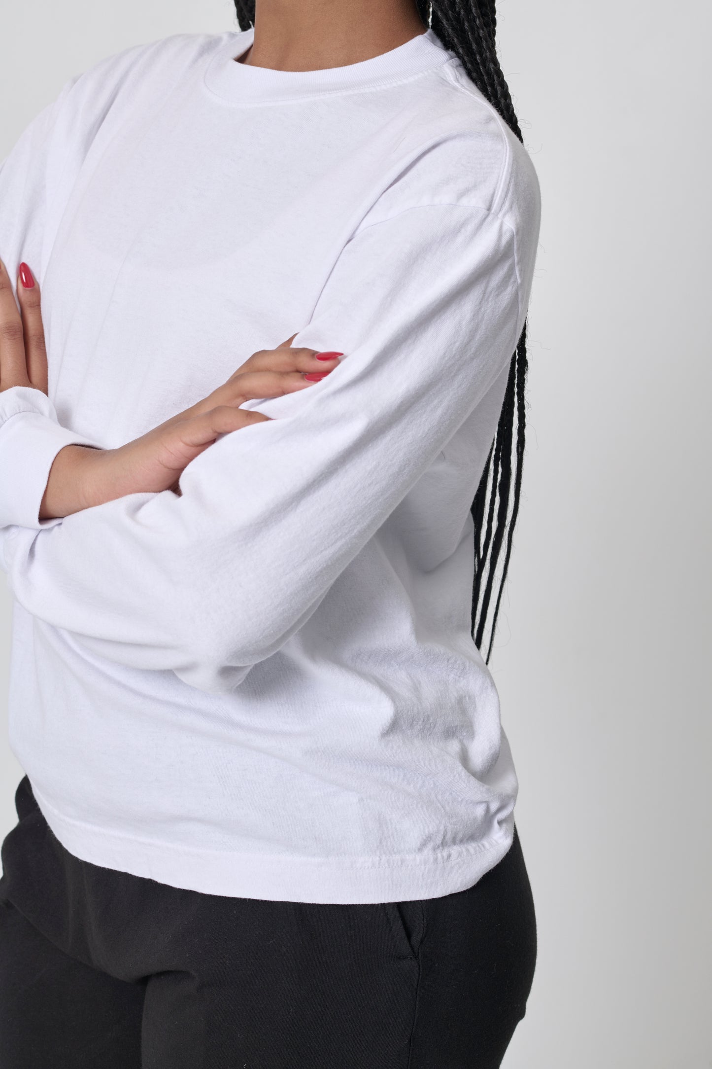 Closeup: woman in White Long Sleeve Trash Tee, showing shoulder and sleeve, and no side seams.