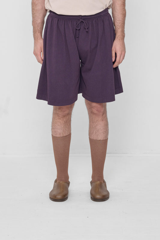 A 6'2" person in Low Rise Mulberry Long Tubular Shorts. Hem ends at the knee.