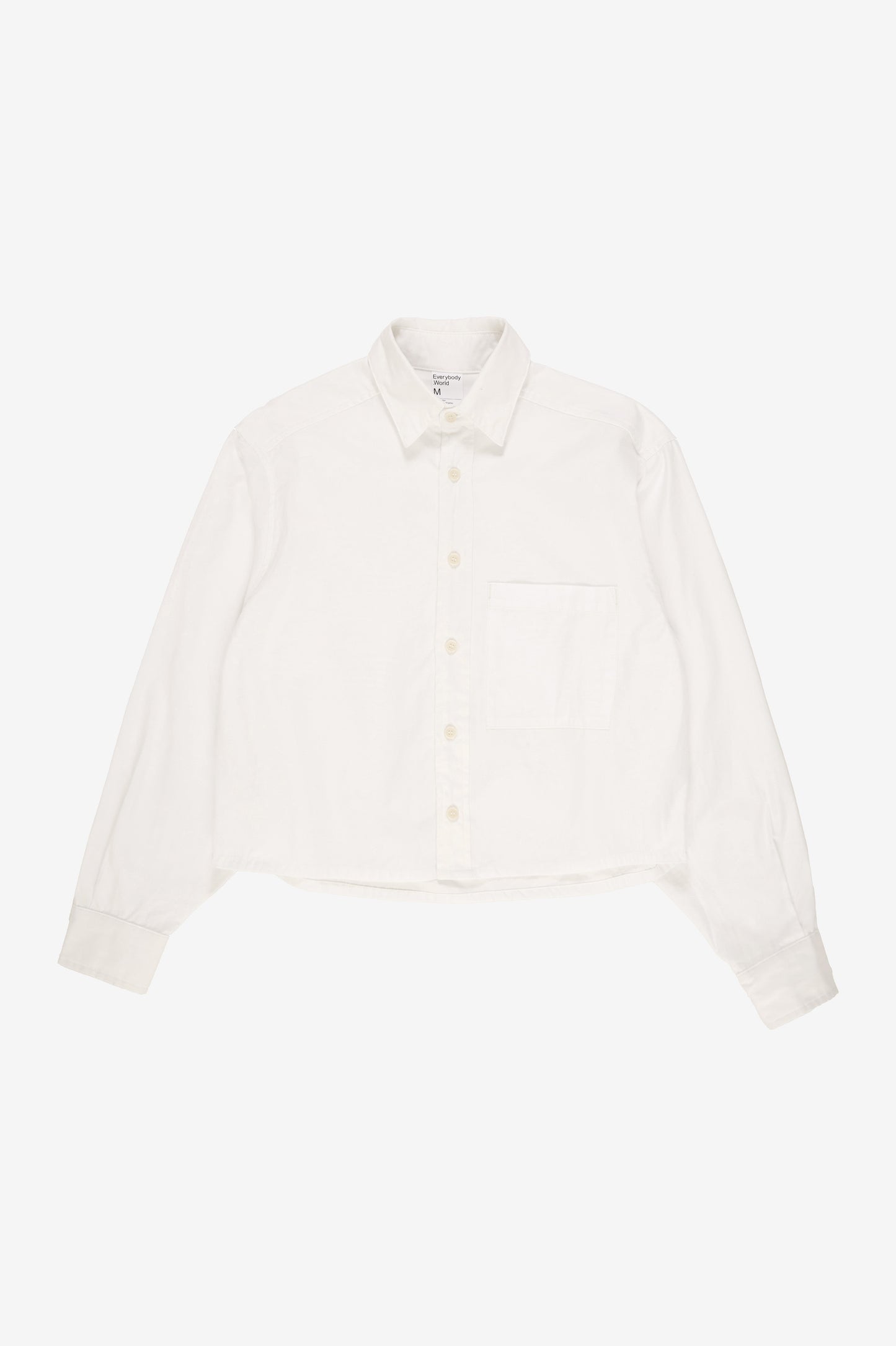 Flat lay showing boxy cropped body and straight bottom hem.