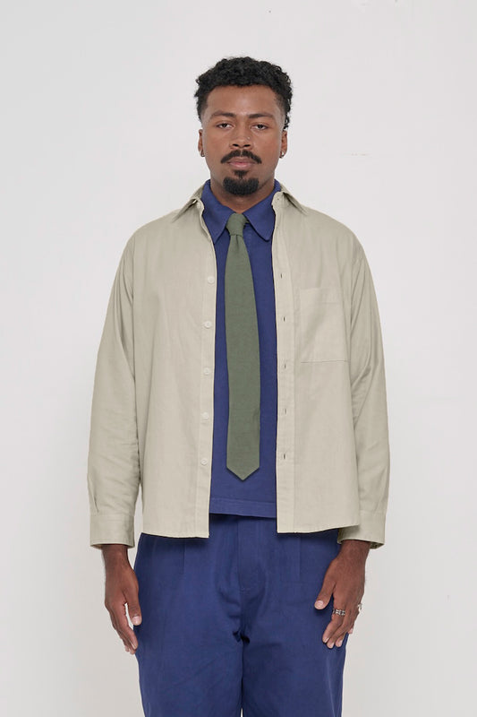 Oat Peach Fuzz Twill Button Up Shirt, worn open, with Washed Navy Trash Polo, Pine Green Trash Tie.