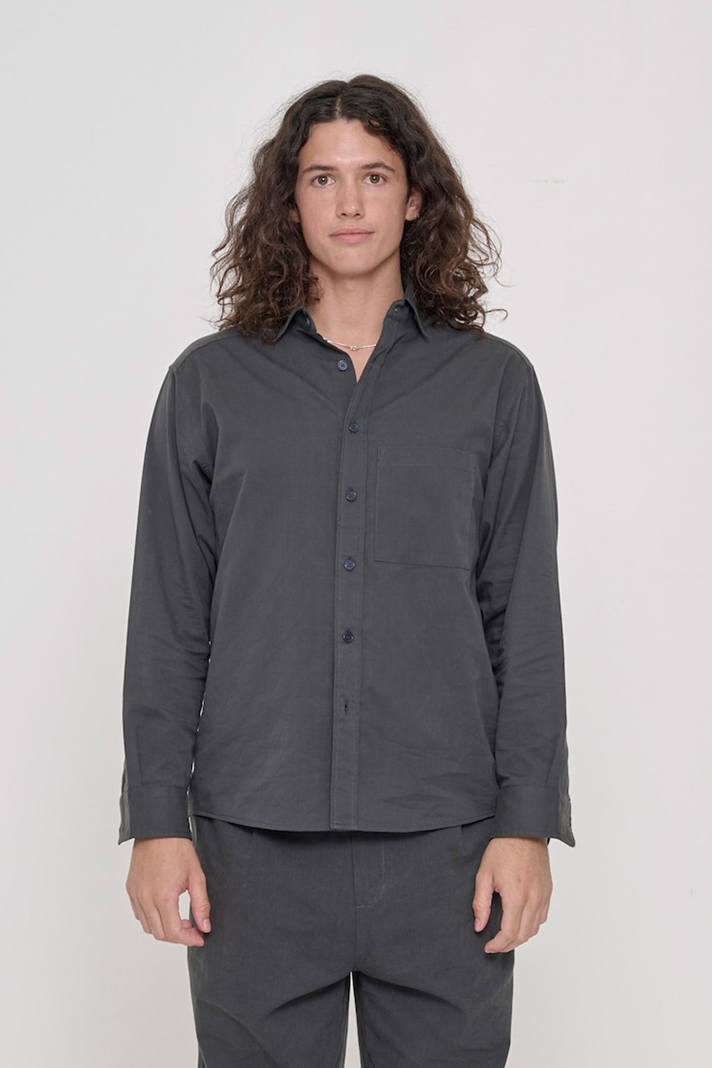 Person in a Slate Peach Fuzz Twill Button Up Shirt, buttoned up and worn with matching Cotton Twill Life Uniform Pants.
