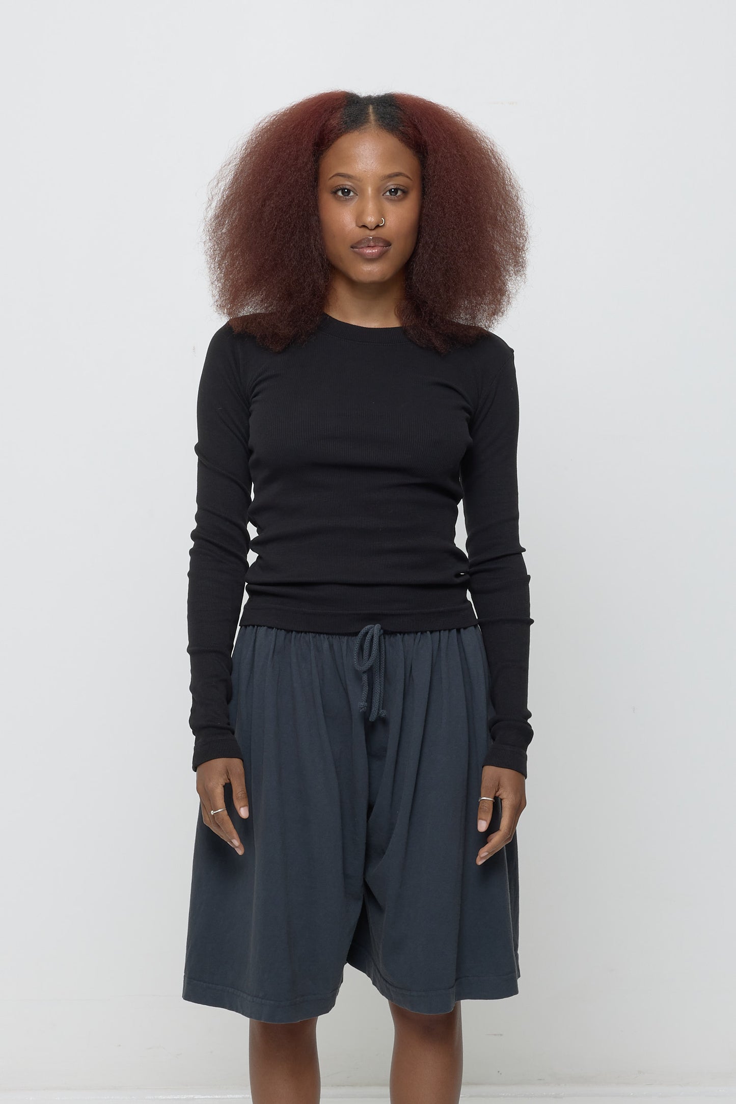 5'3" woman, size S Black Rib Long Sleeve, hem at hips with intentional bunching.