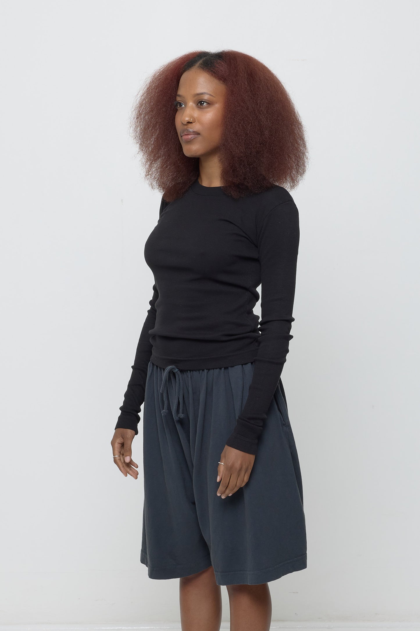 Woman turned 45-degrees from the front, shows side seams and fitted silhouette.