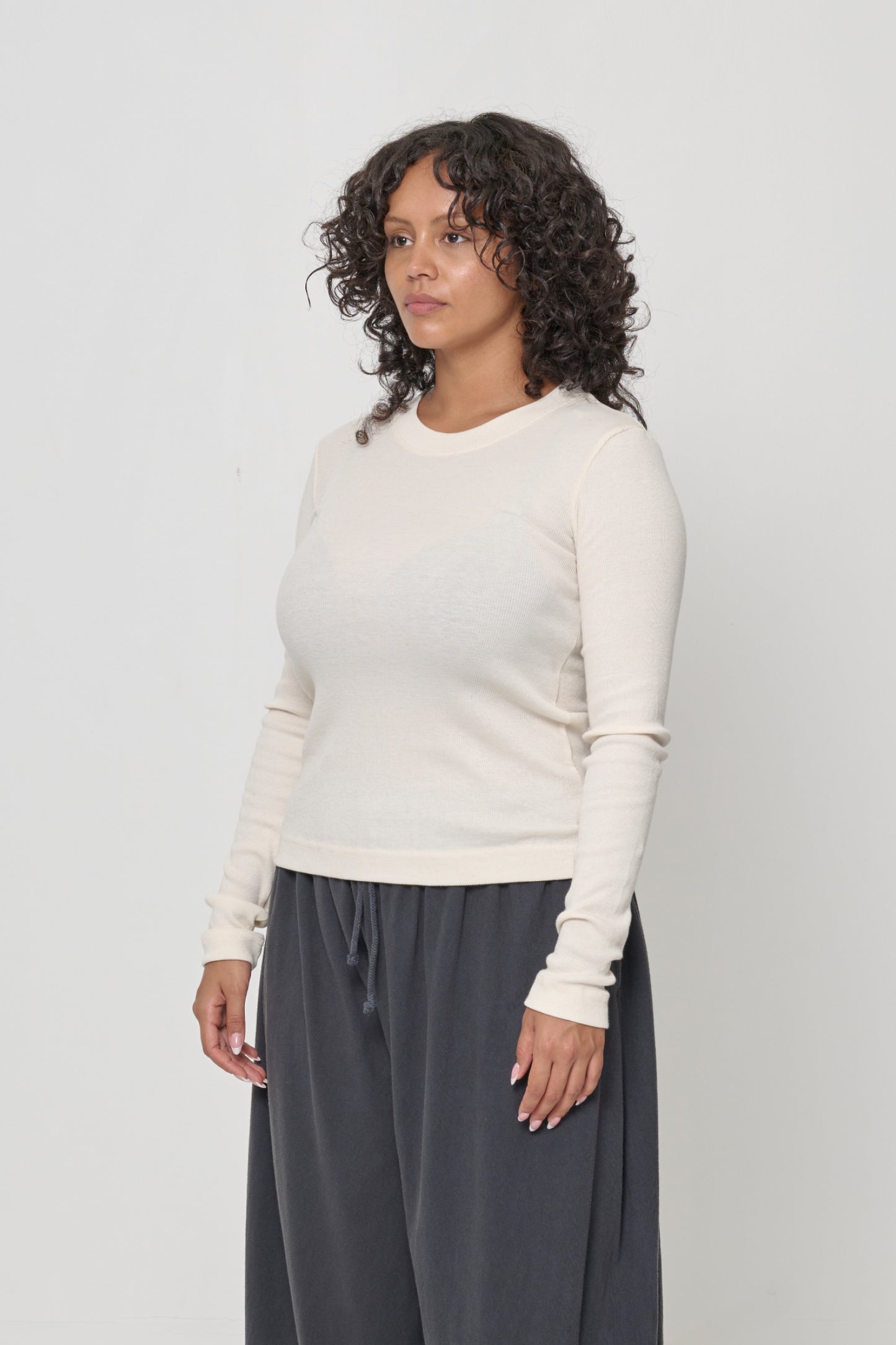 Woman turned 45-degrees from the front, shows side seams and fitted silhouette.