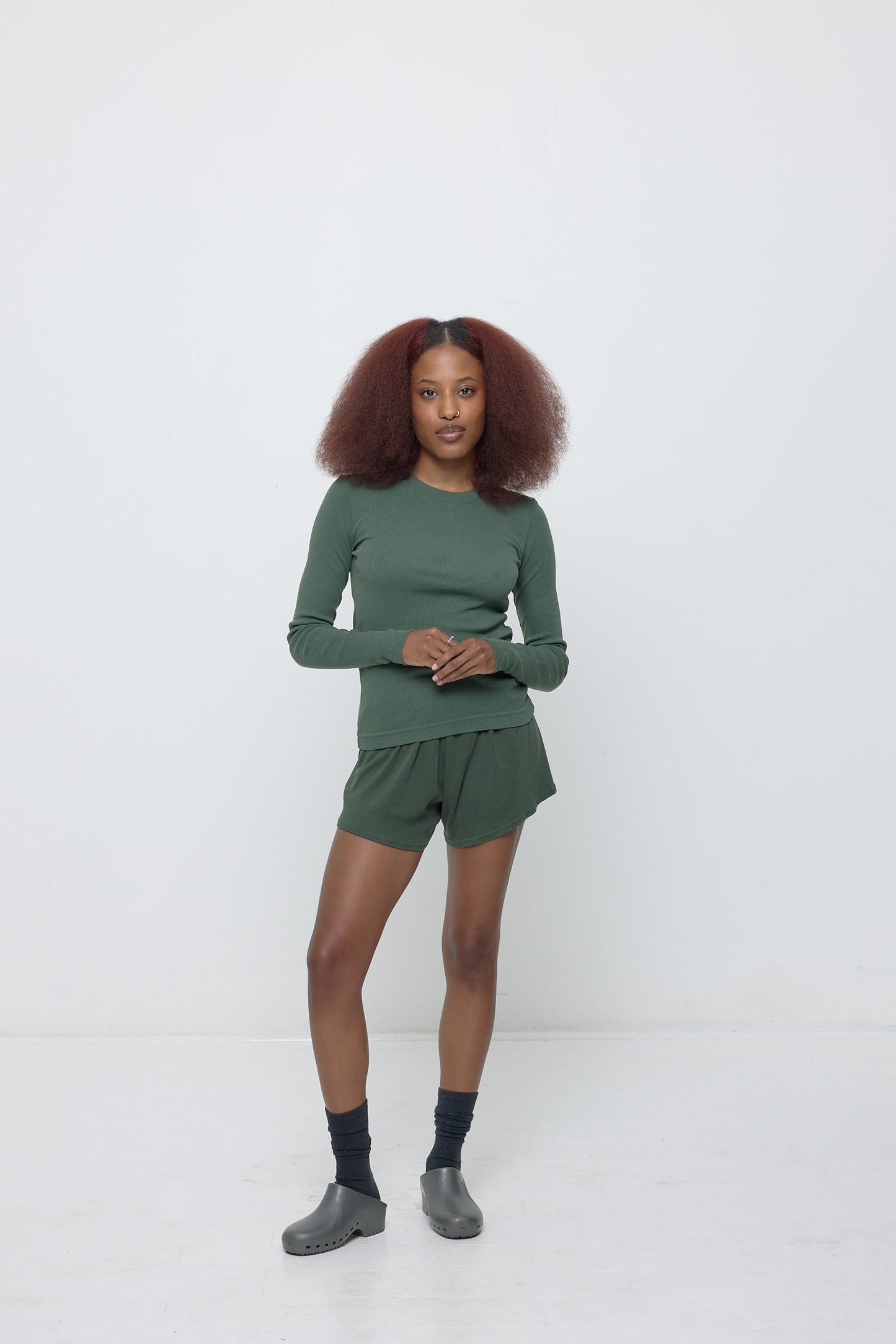 A person wearing Pine Rib Shorts with a matching Rib Long Sleeve.