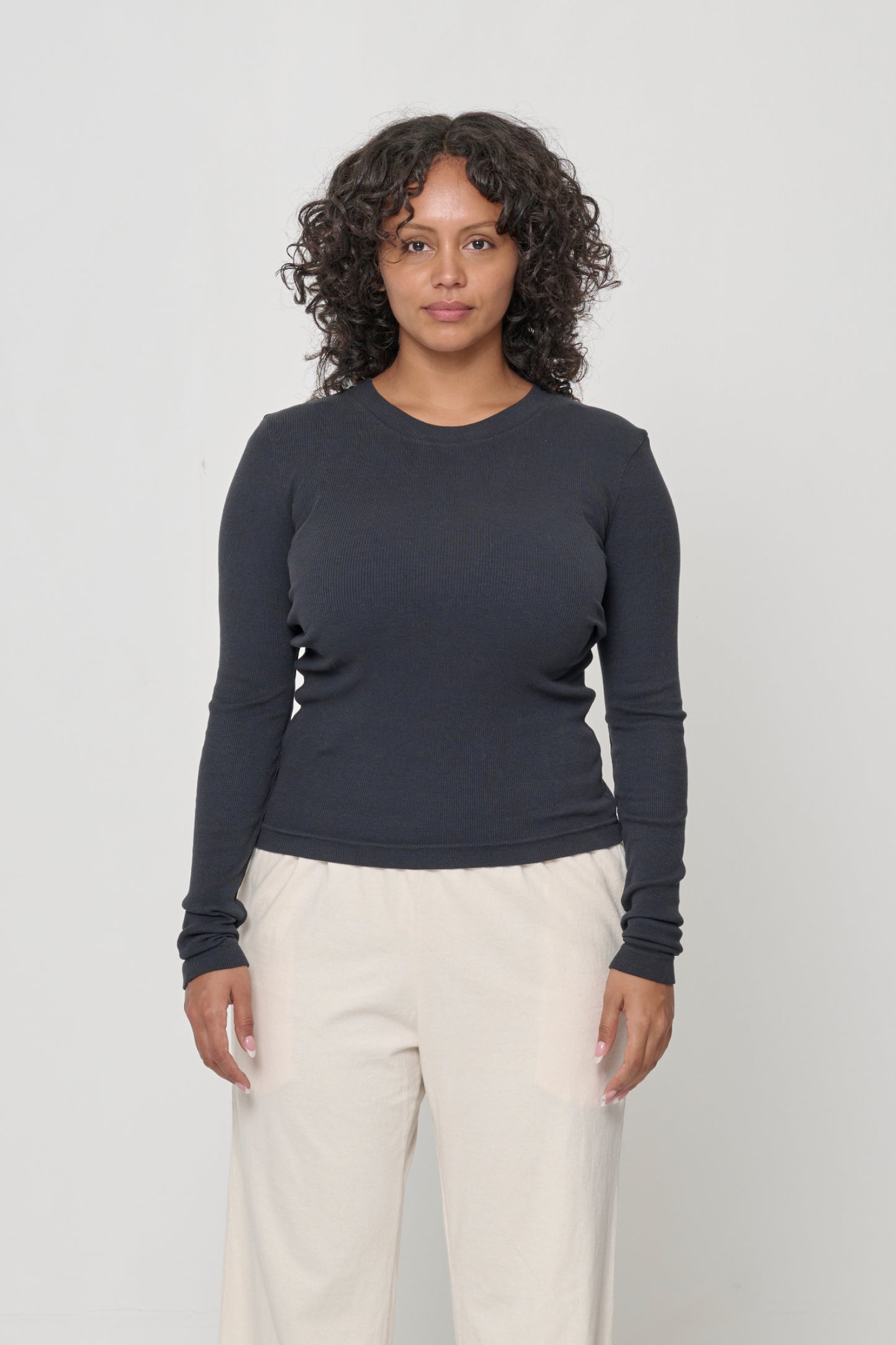 Front view of a 5'7" woman wearing a size M Rib Long Sleeve in Slate. Heavy bottom hem hits the top of her hips.