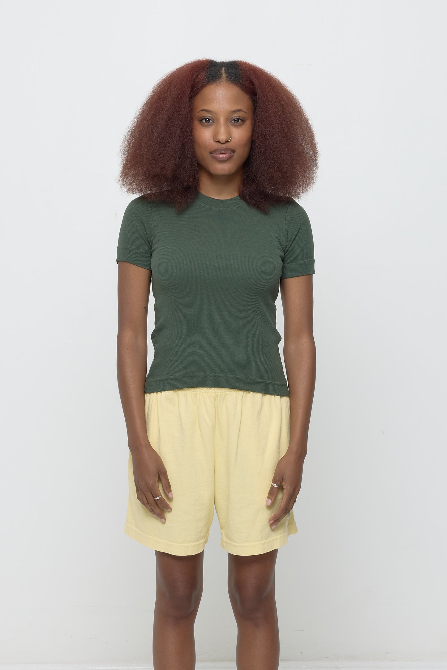 Front view of a 5'3" woman wearing a size S Rib Short Sleeve in Pine. Hem rests on her upper hips.