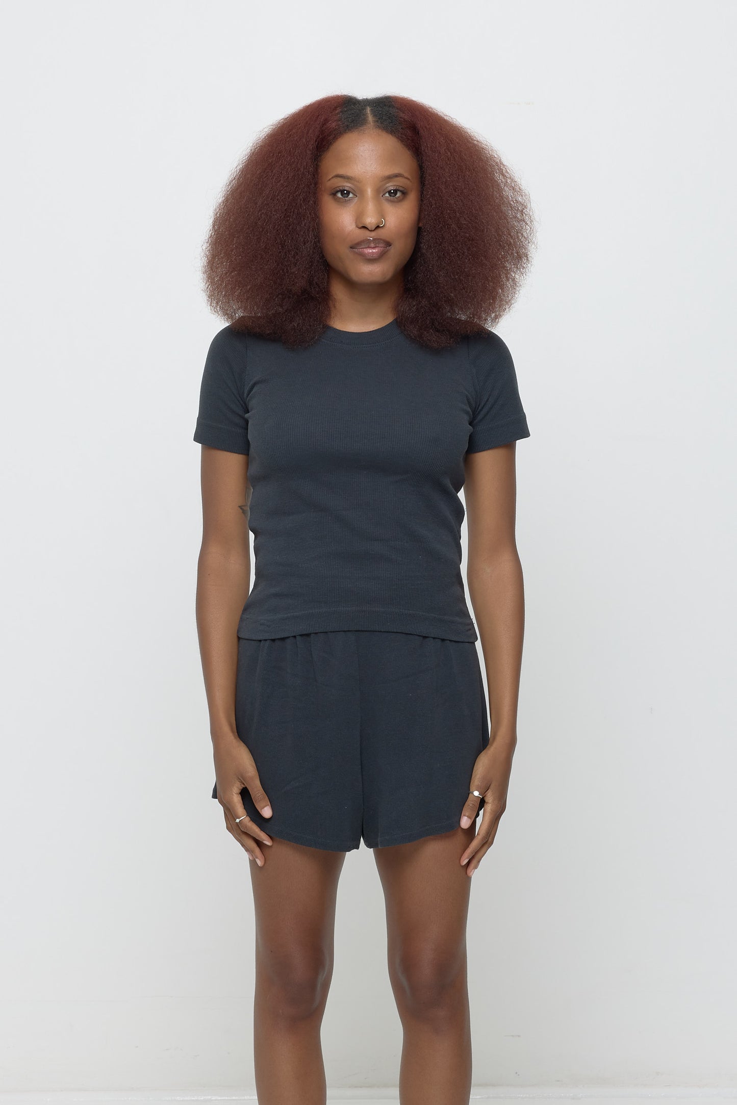 Front view of a 5'3" woman wearing a size S Rib Short Sleeve in Slate. Hem rests on her upper hips.