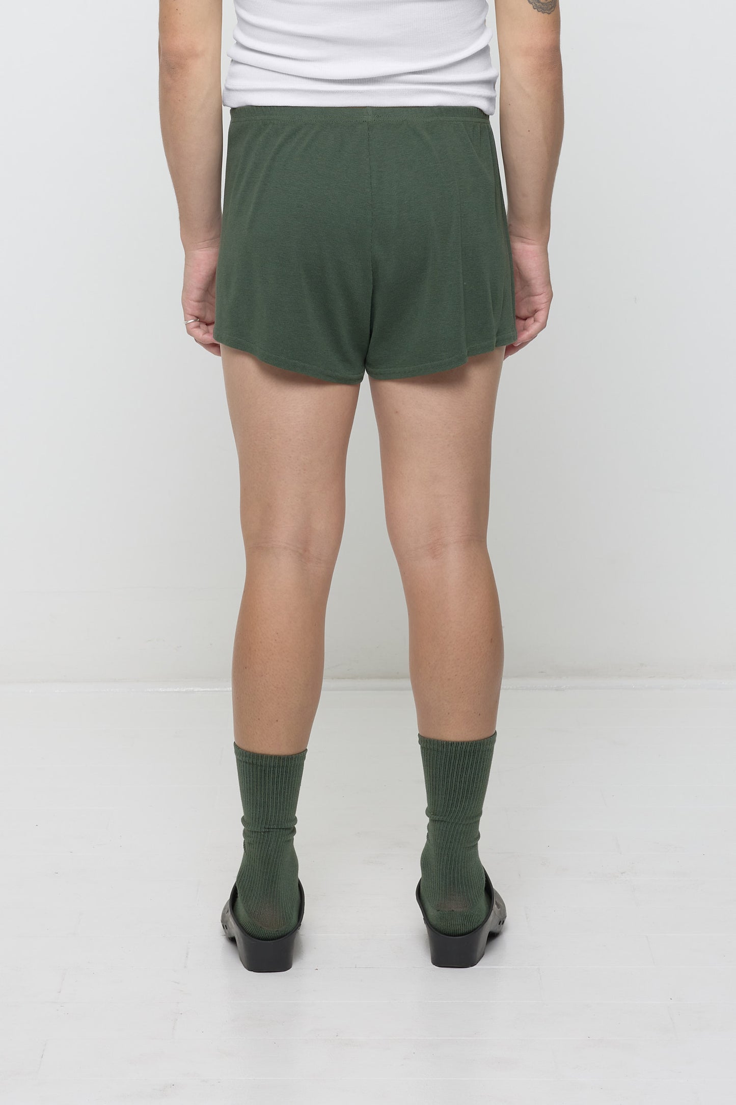 Back view: A model wearing Pine Rib Shorts, which feature a relaxed fit and a flowing, drapey fabric.