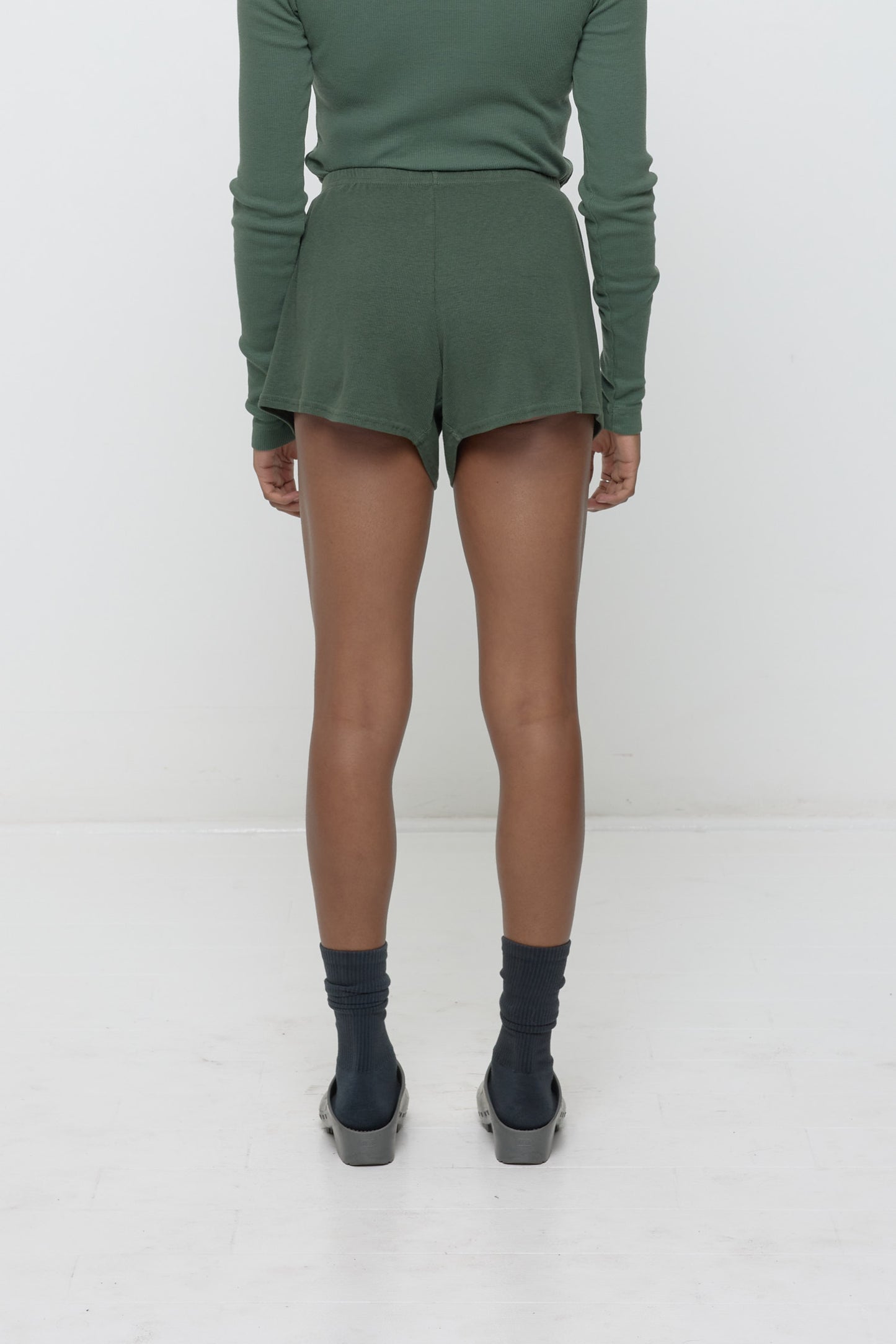 Back view: A woman wearing Pine Rib Shorts, which feature a relaxed fit and a flowing, drapey fabric.