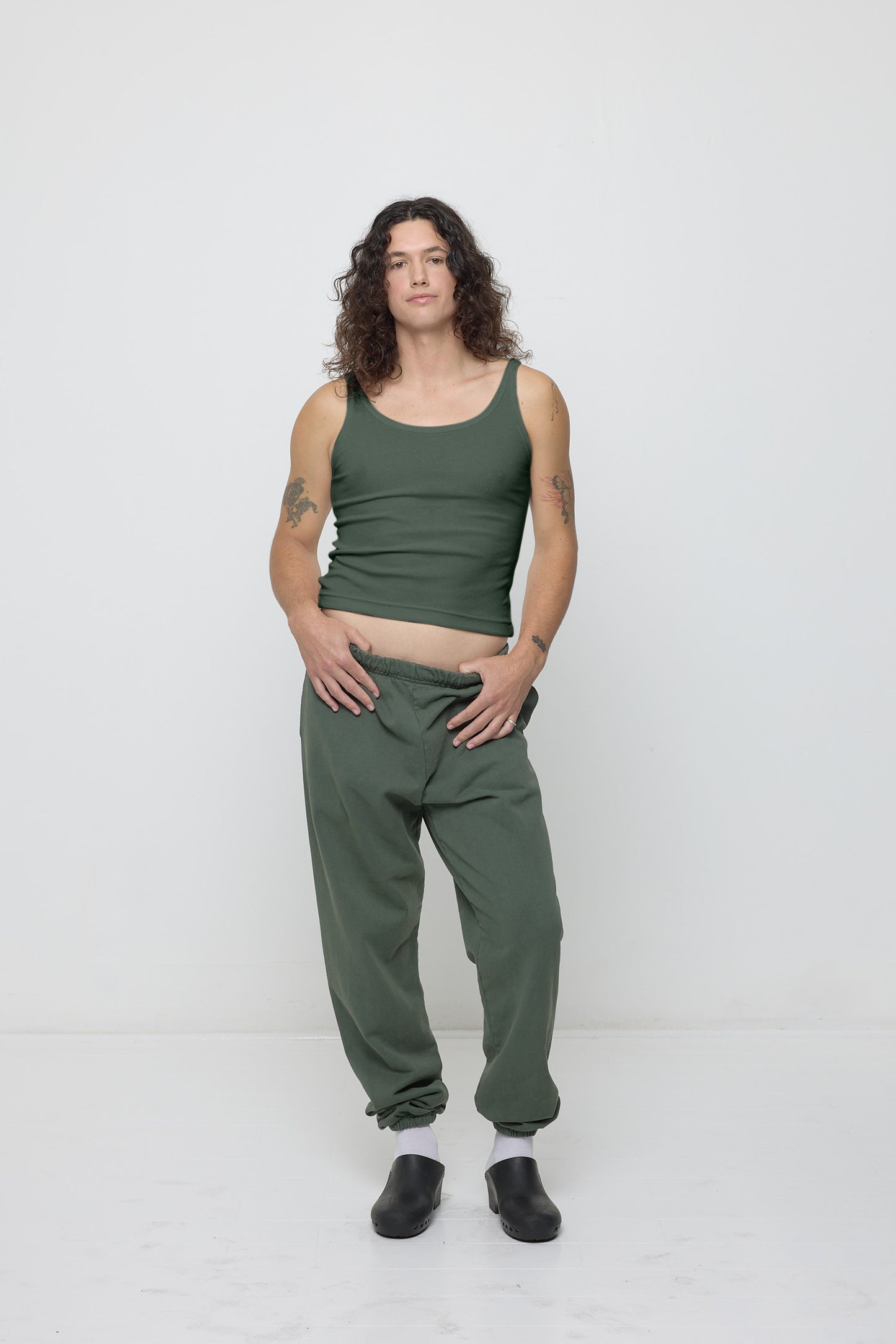 Front view of a person wearing a Rib Tank in Pine with a matching pair of Trash Sweatpants.