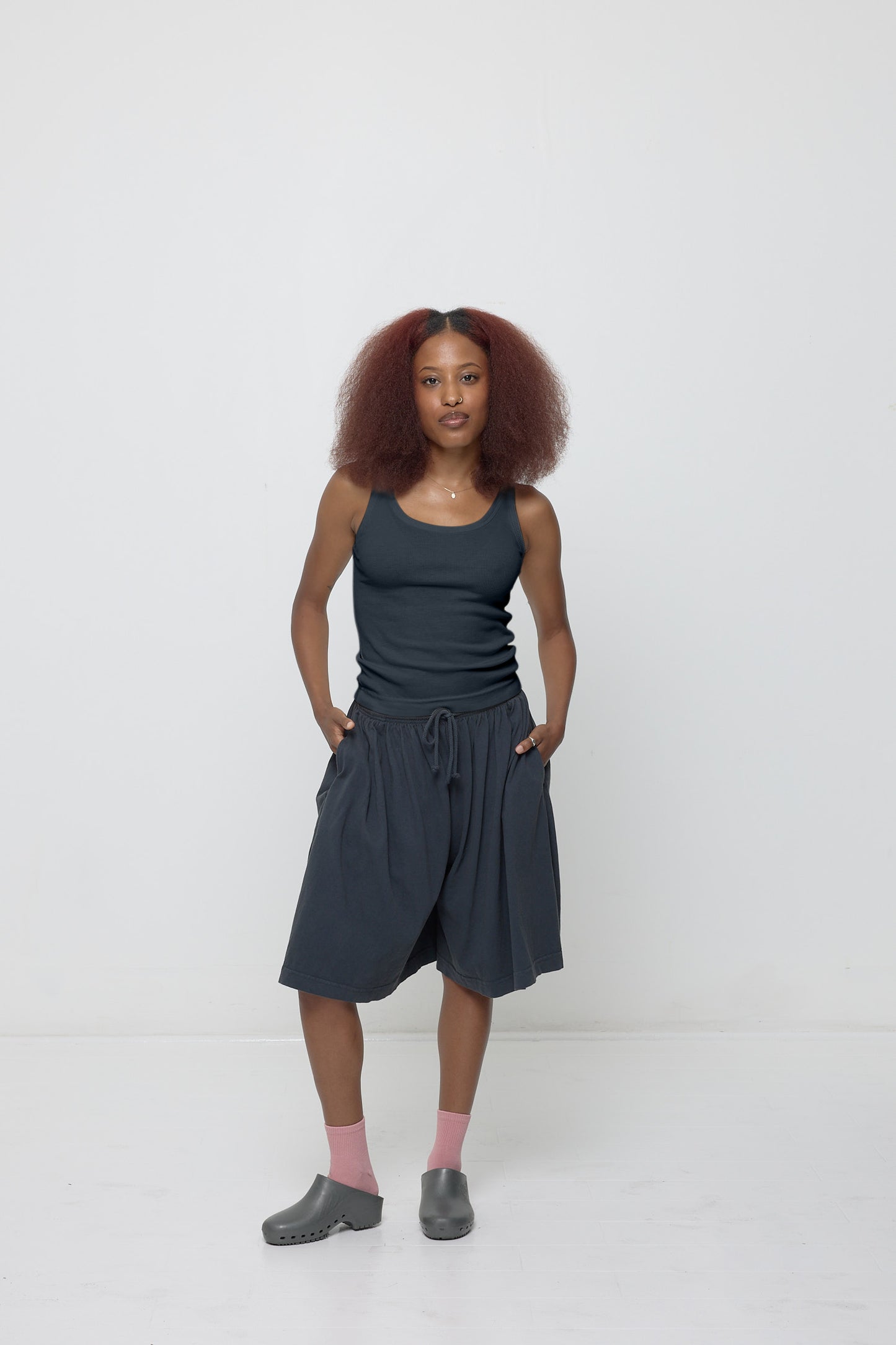 Woman wearing a Slate Rib Tank and matching Long Tubular Shorts with Metallic Grey Calzuro Classic Clogs.