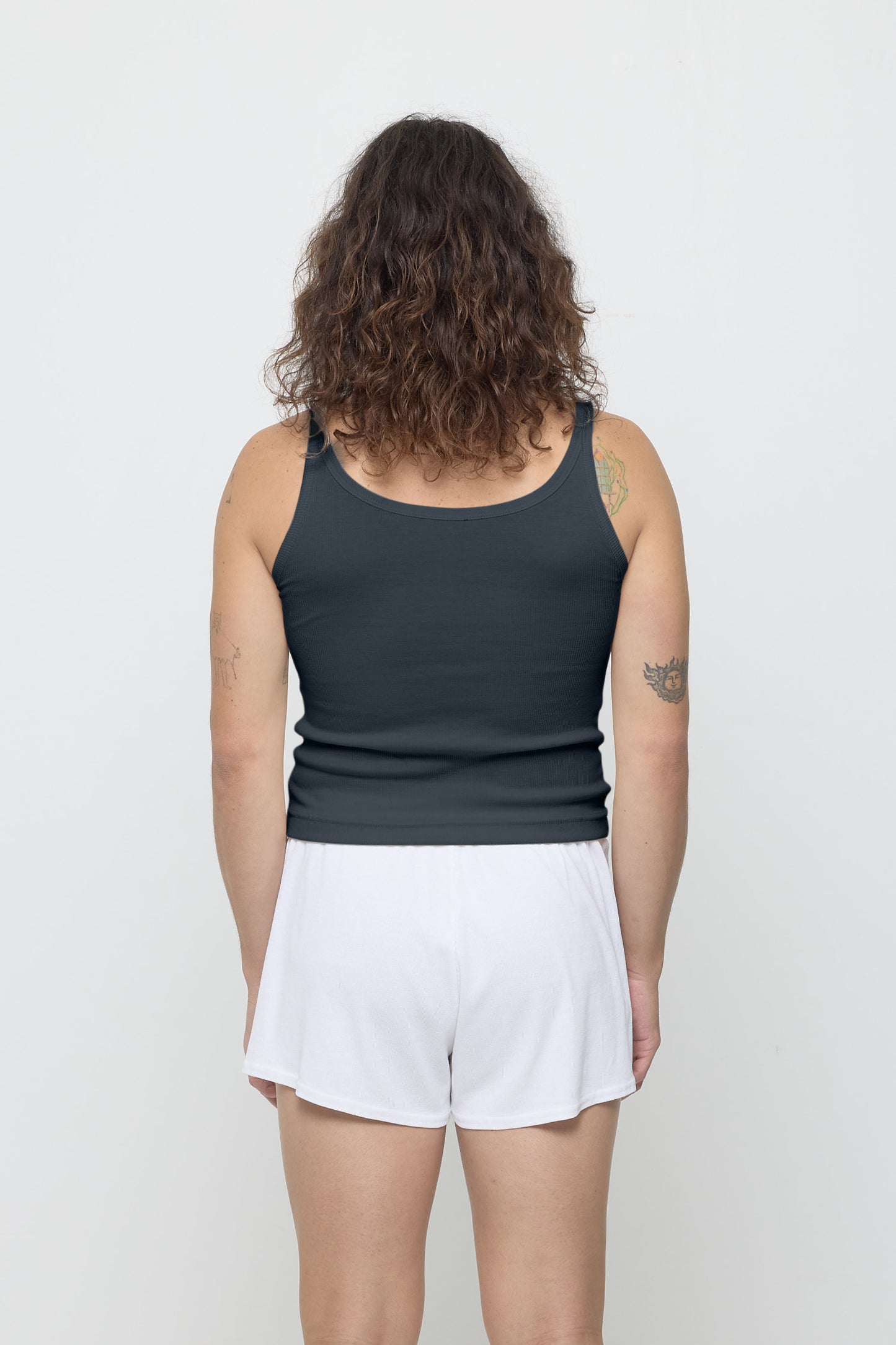 Back view: a person in Slate Rib Tank, fitted upper back, relaxed lower back.