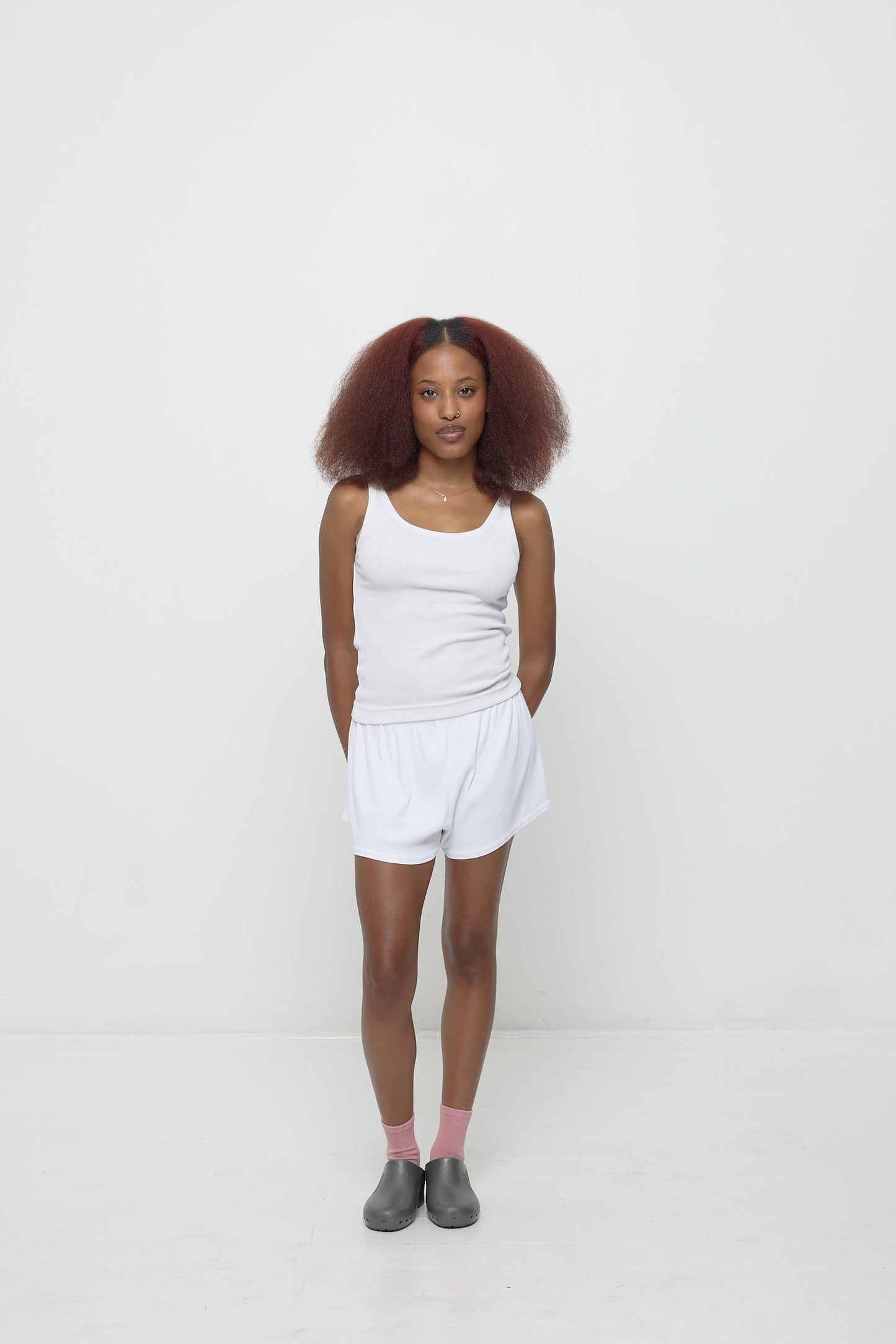 Woman wearing a White Rib Tank and matching Rib Shorts with Metallic Grey Calzuro Classic Clogs.