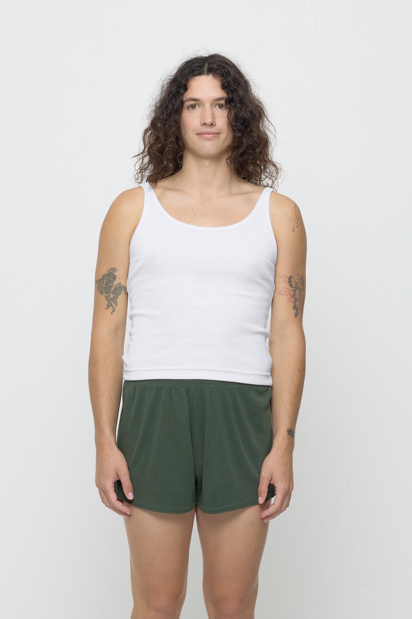 Front view of a 6' person wearing a size S Rib Tank in White. Hem rests on their upper hips.