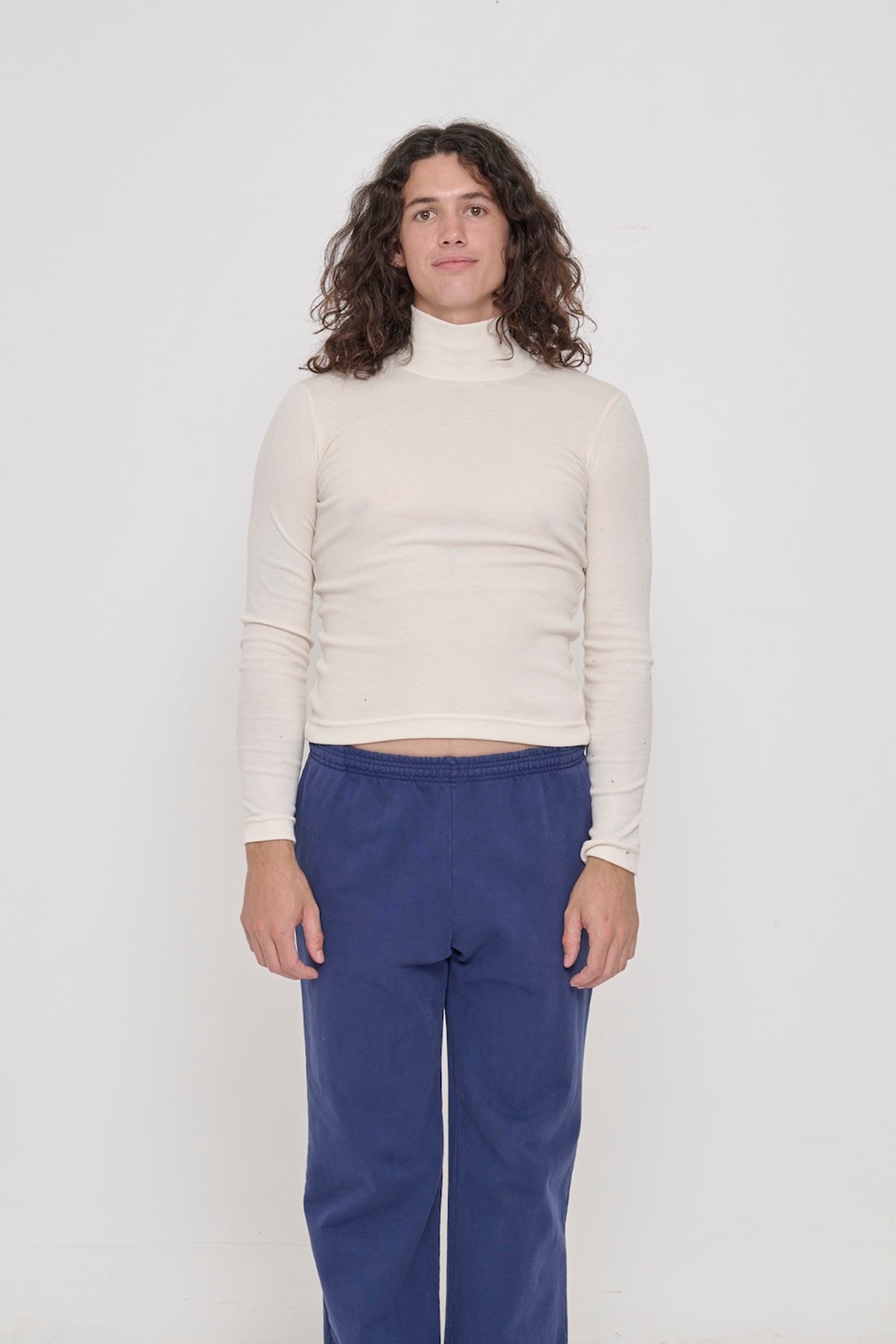 A 6' person in a size M Rib Turtleneck in Natural. Hem rests above their hips.