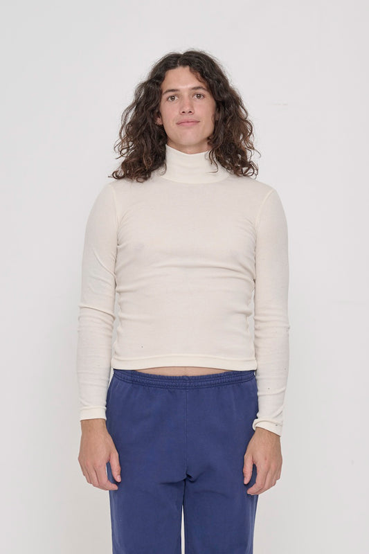 A 6' person in a size M Rib Turtleneck in Natural. Hem rests above their hips.