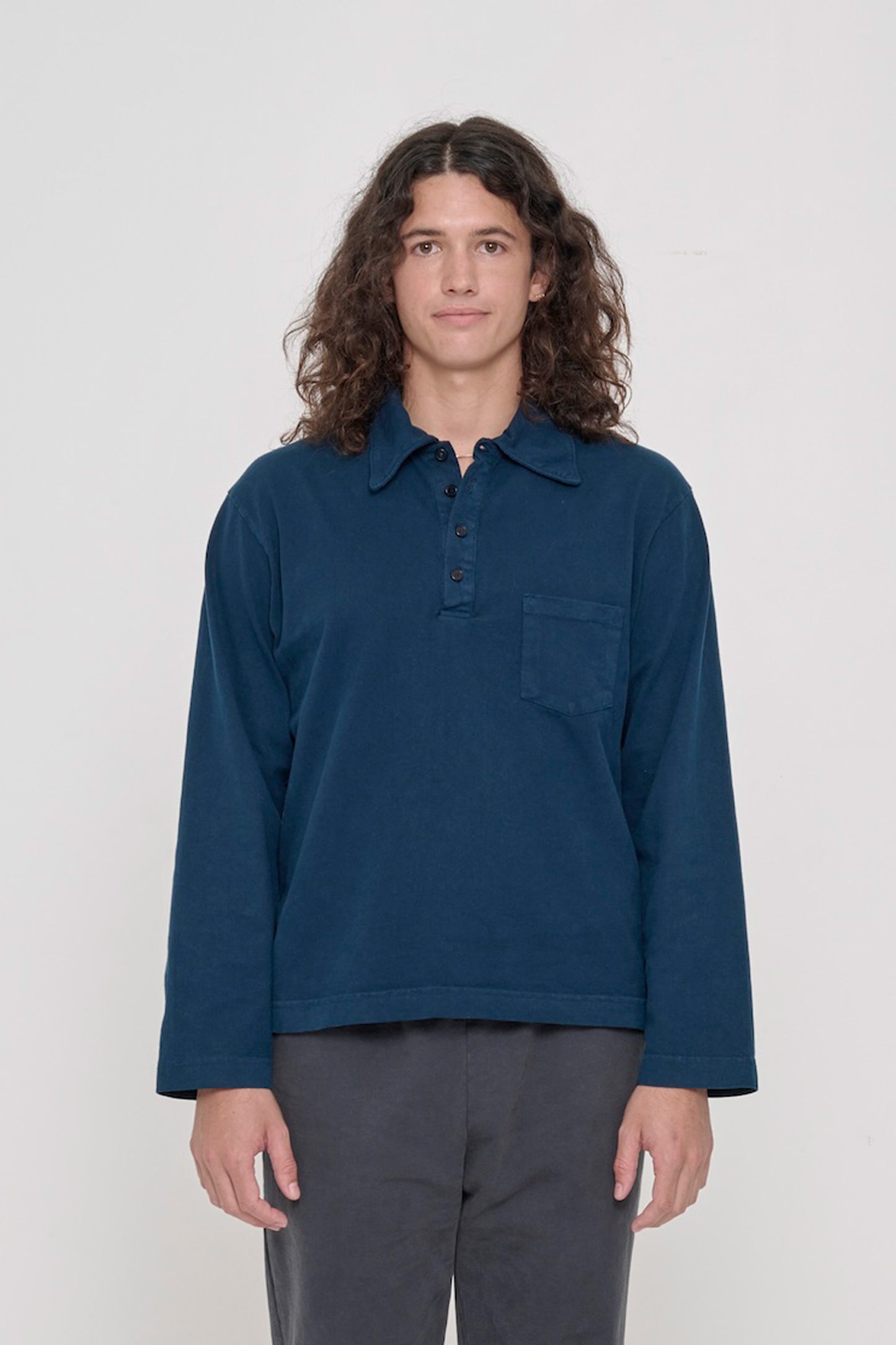 Front view of a 6' person wearing a size M Rugby Trash Polo in Juniper. Hem hits lower-mid hip.