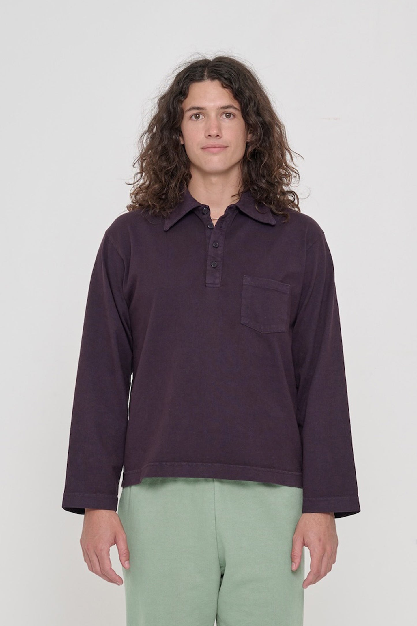 Front view of a 6' person wearing a size M Rugby Trash Polo in Mulberry. Hem hits lower-mid hip.