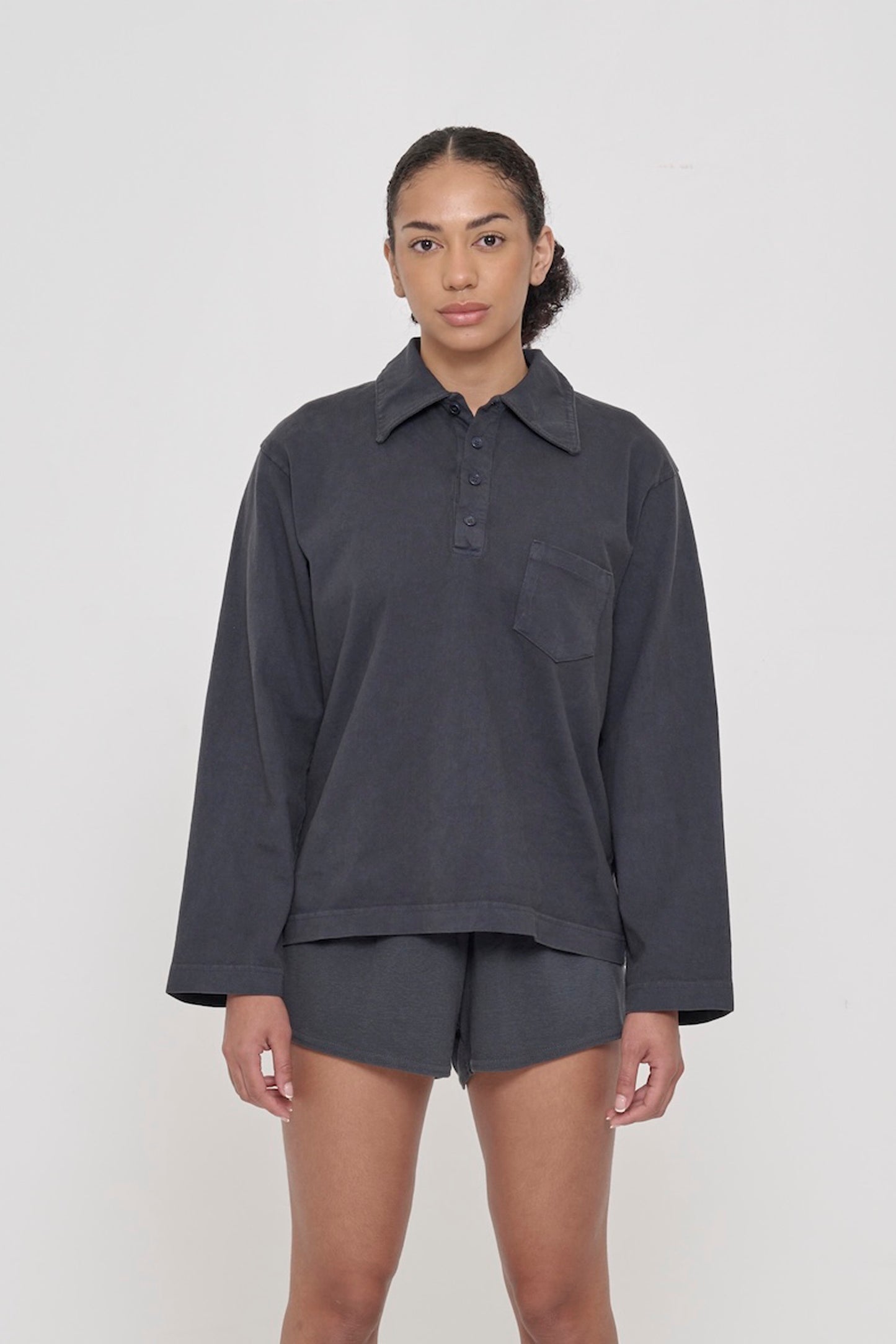 Front view of a 5’8” person wearing a size S Rugby Trash Polo in Slate. Hem hits mid-hip.