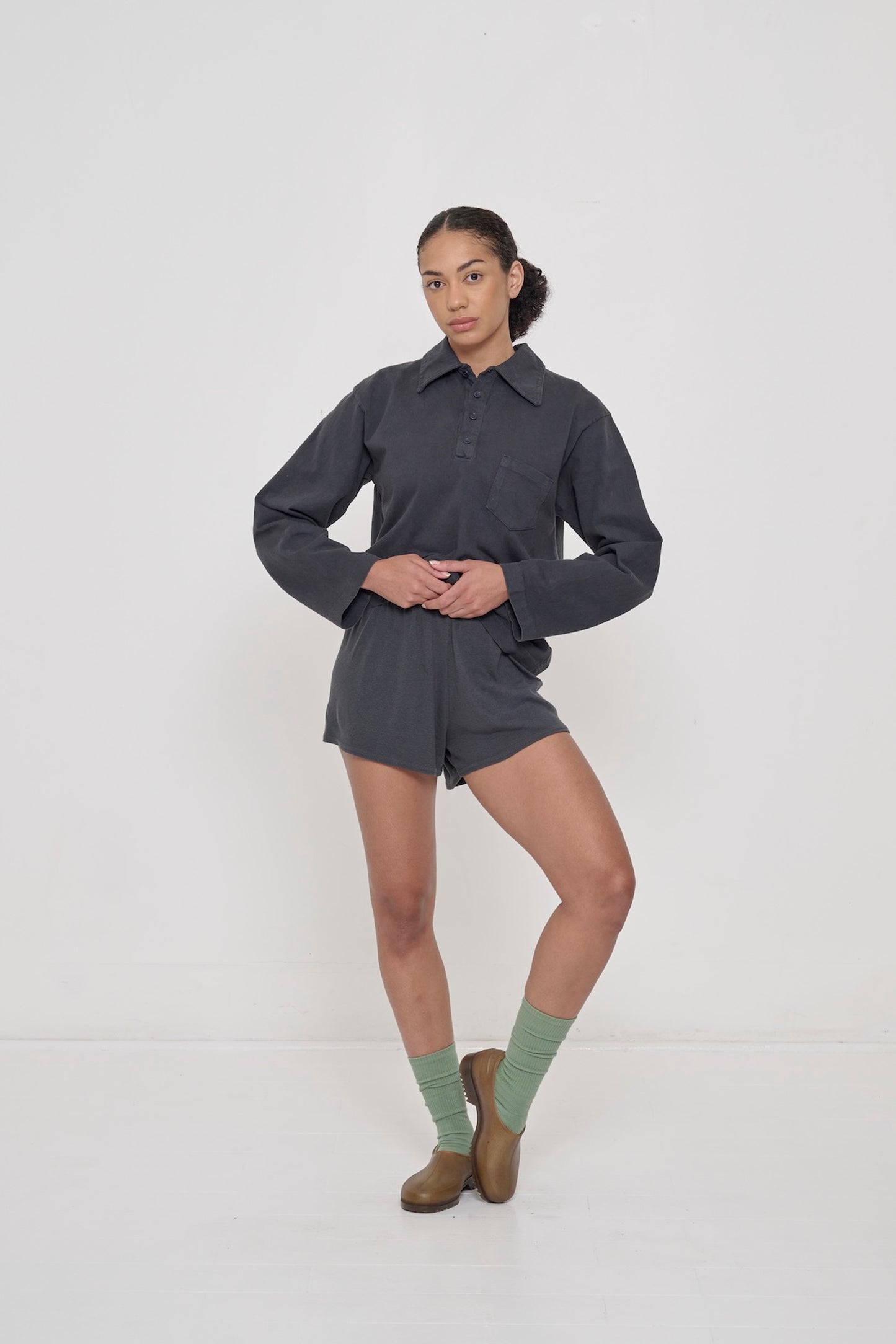 Woman wearing Slate Rugby Trash Polo with matching Slate Rib Shorts.