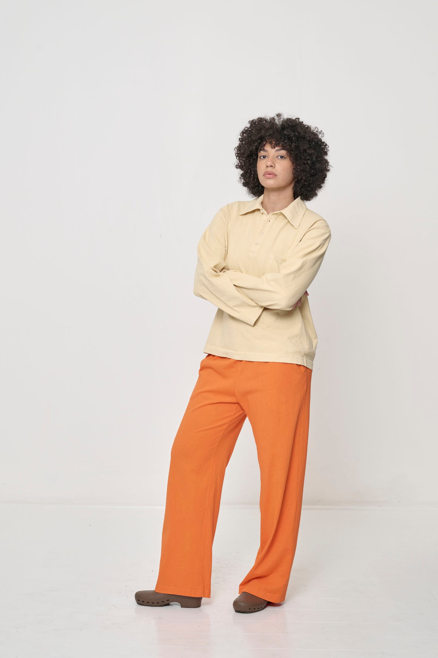 Woman wearing Turtle Dove Rugby Trash Polo with Persimmon Apartment Pants.