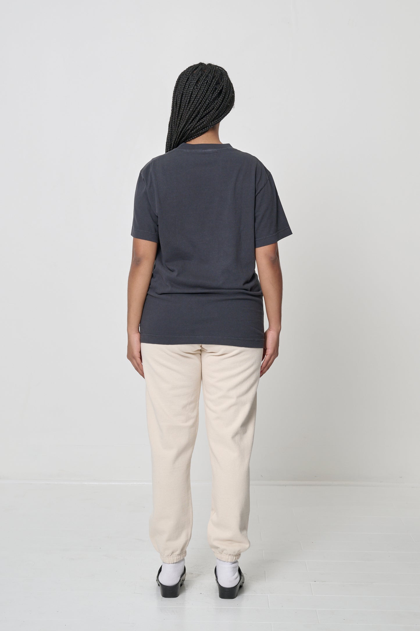 Back view of a woman wearing the Short Sleeve Trash Tee in Slate, showing the back of the crew neckline.