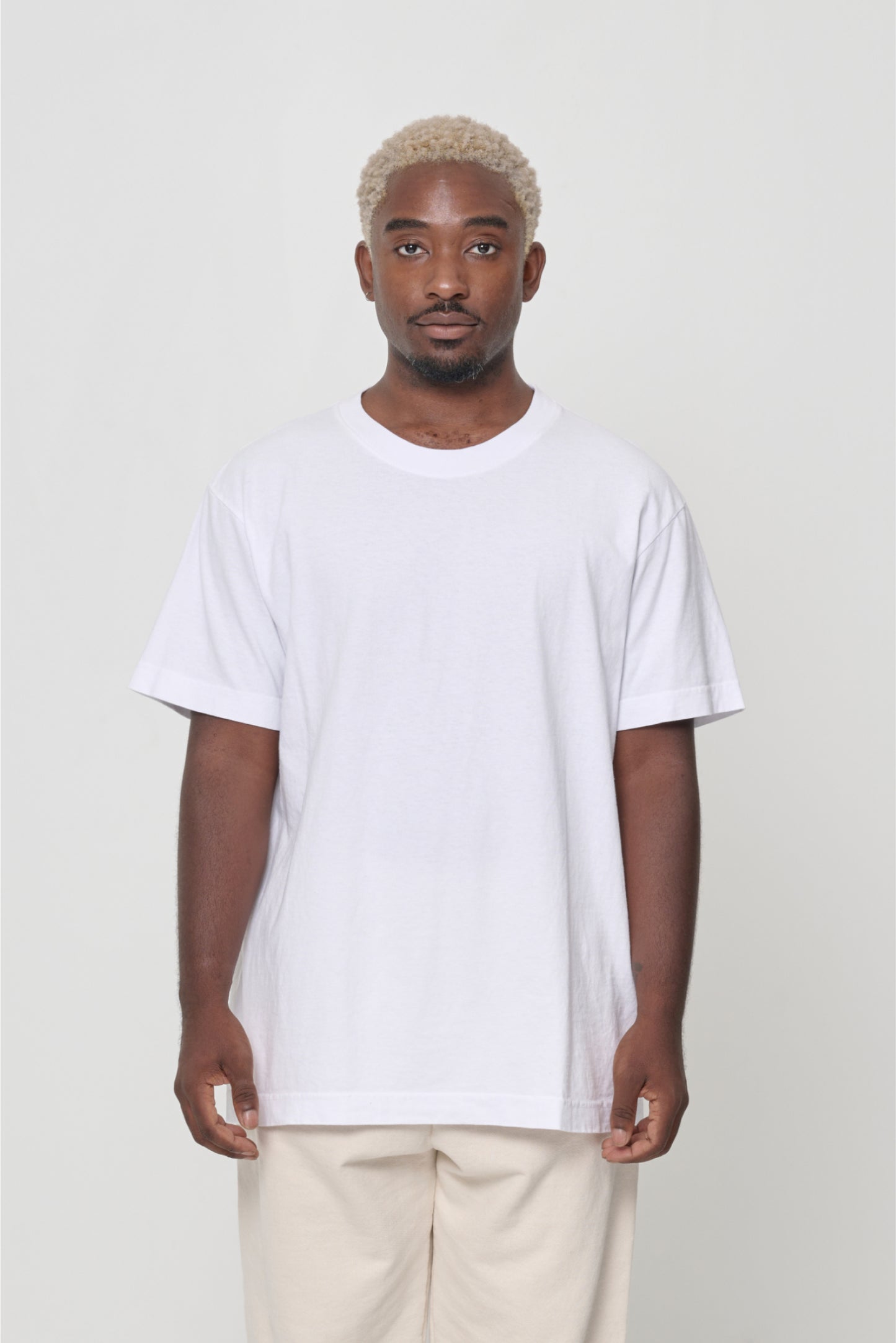 Front view of a man wearing the Short Sleeve Trash Tee in White, showcasing its relaxed fit.