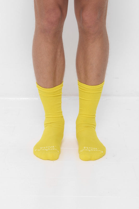 Everybody Yellow Socks, branded 'Everybody.World' at the toe, are calf-high, shown on a person's lower legs.