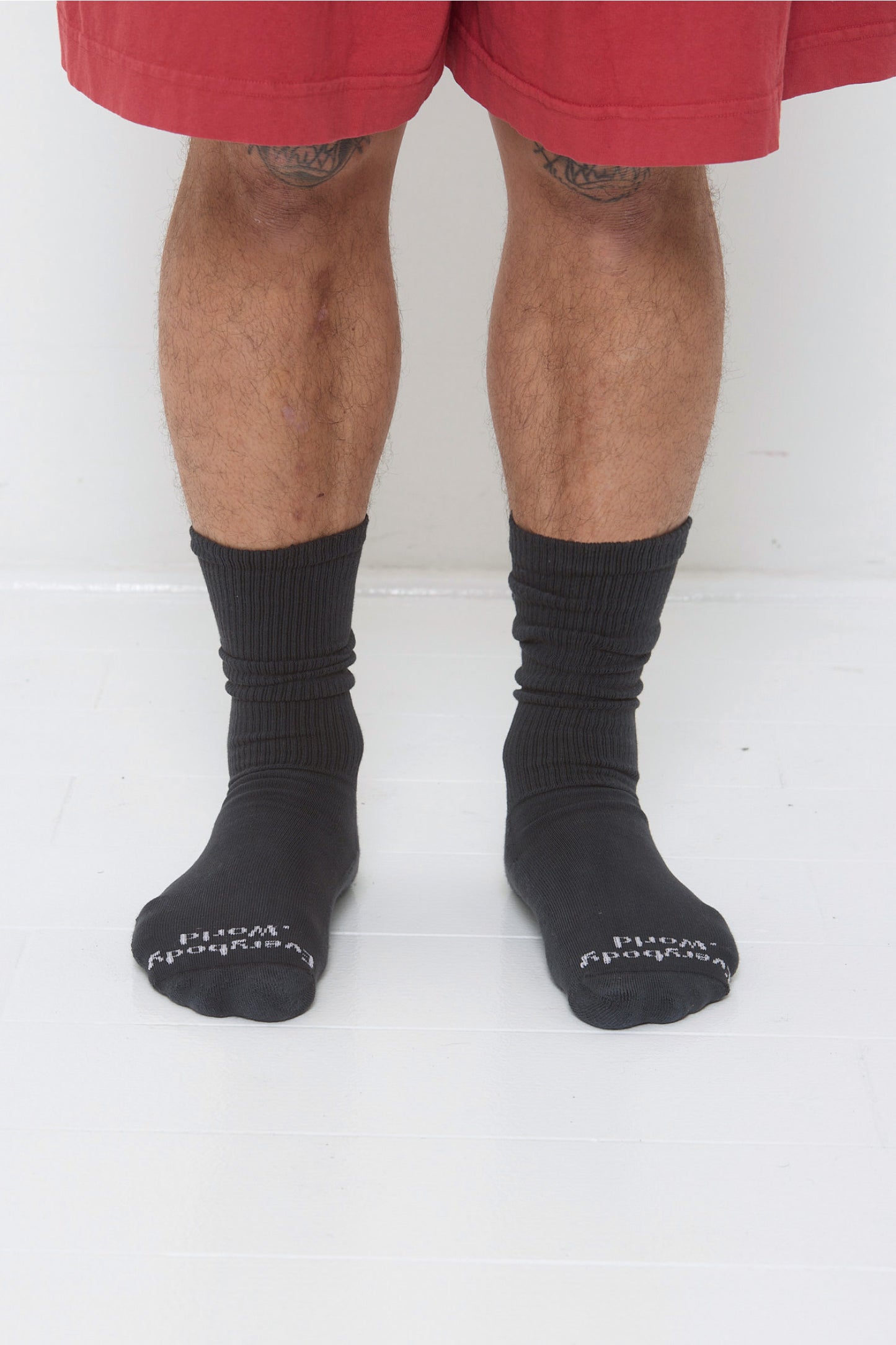 Slate Squishy Socks, branded 'Everybody.World' at the toe, are calf-high, shown on a person's lower legs.