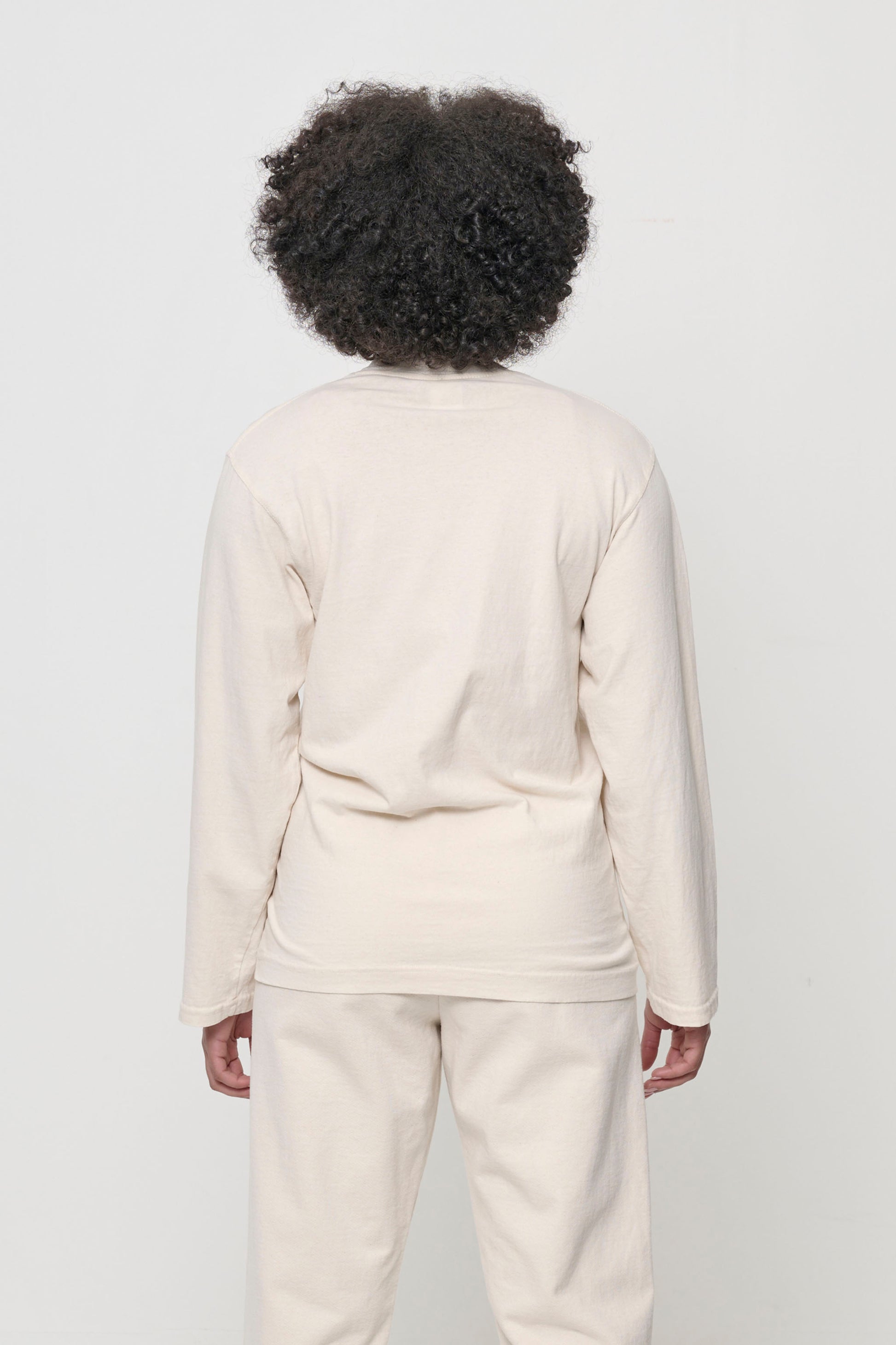 Close up back view of a woman wearing the Straight Sleeve Trash Tee, showing a relaxed fit throughout.