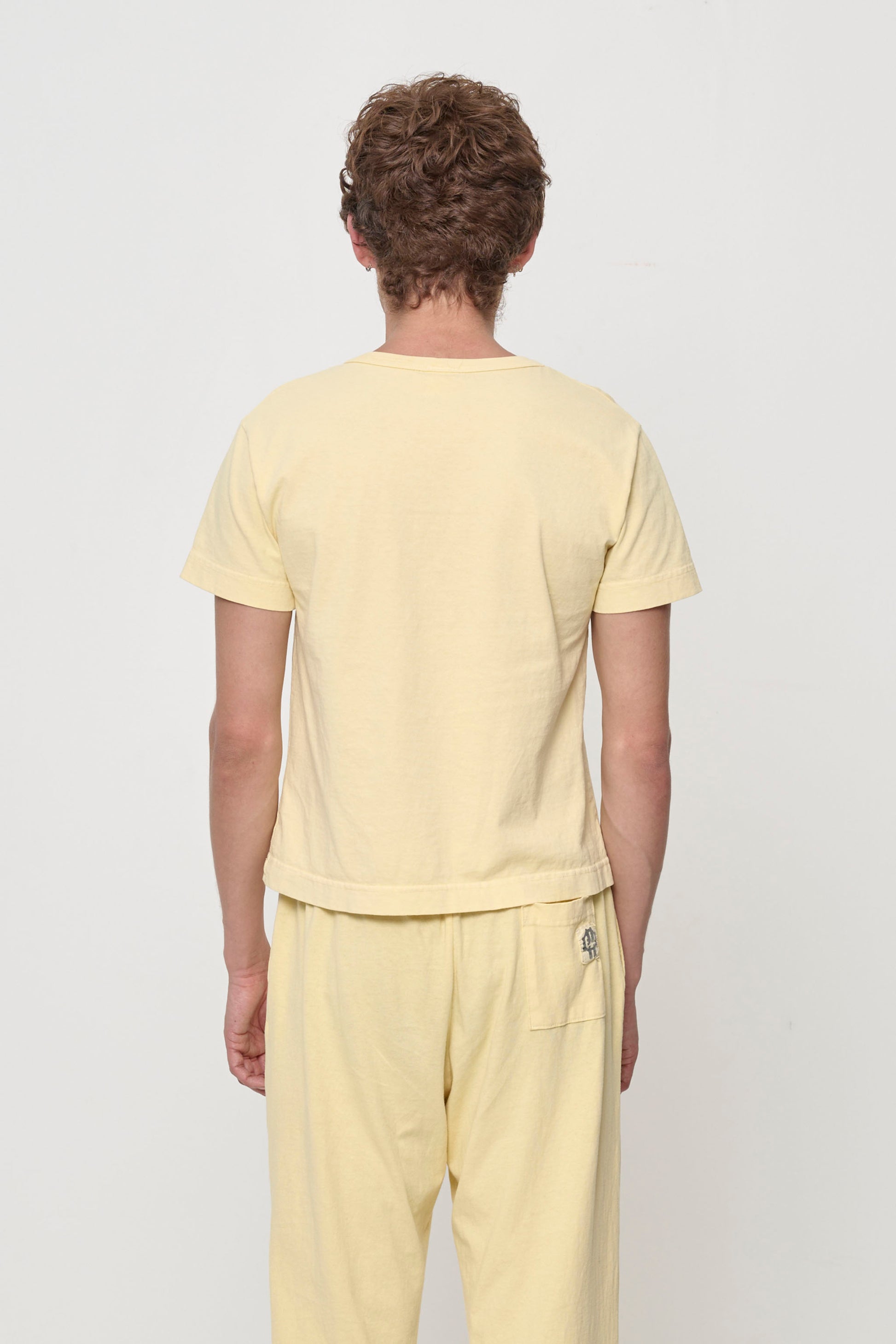 Tailored Trash Tee in French Butter, back view on a person - fitted across upper back and relaxed at middle and lower back