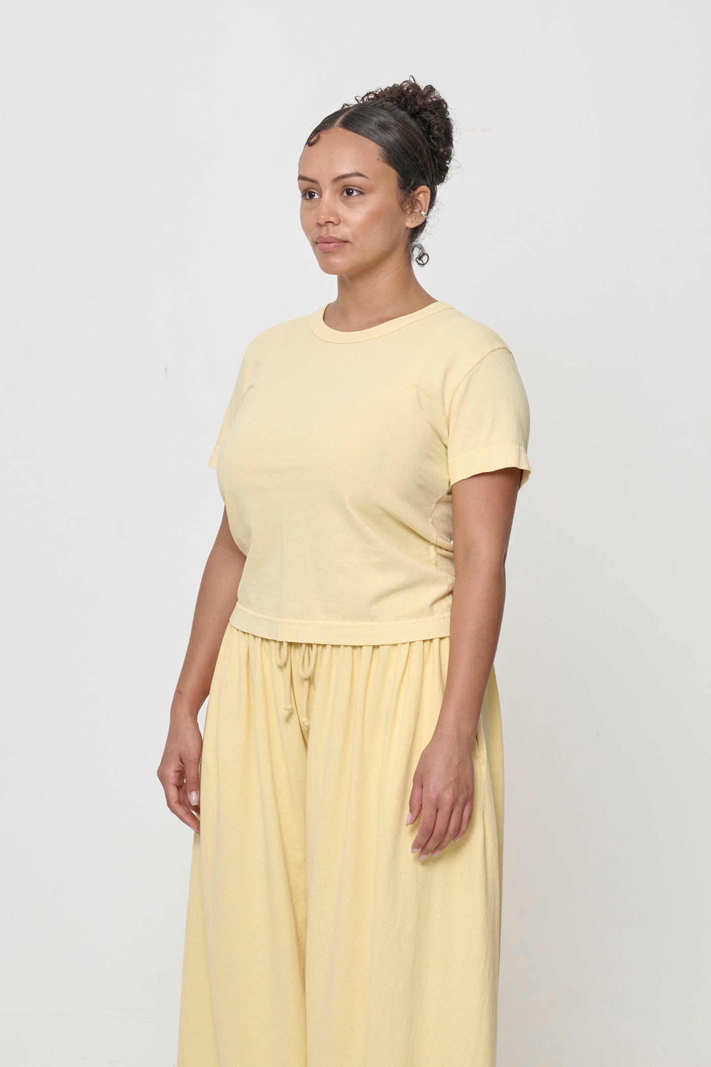Tailored Trash Tee in French Butter - 3/4 front view on person, showing side seams and slim short sleeves.
