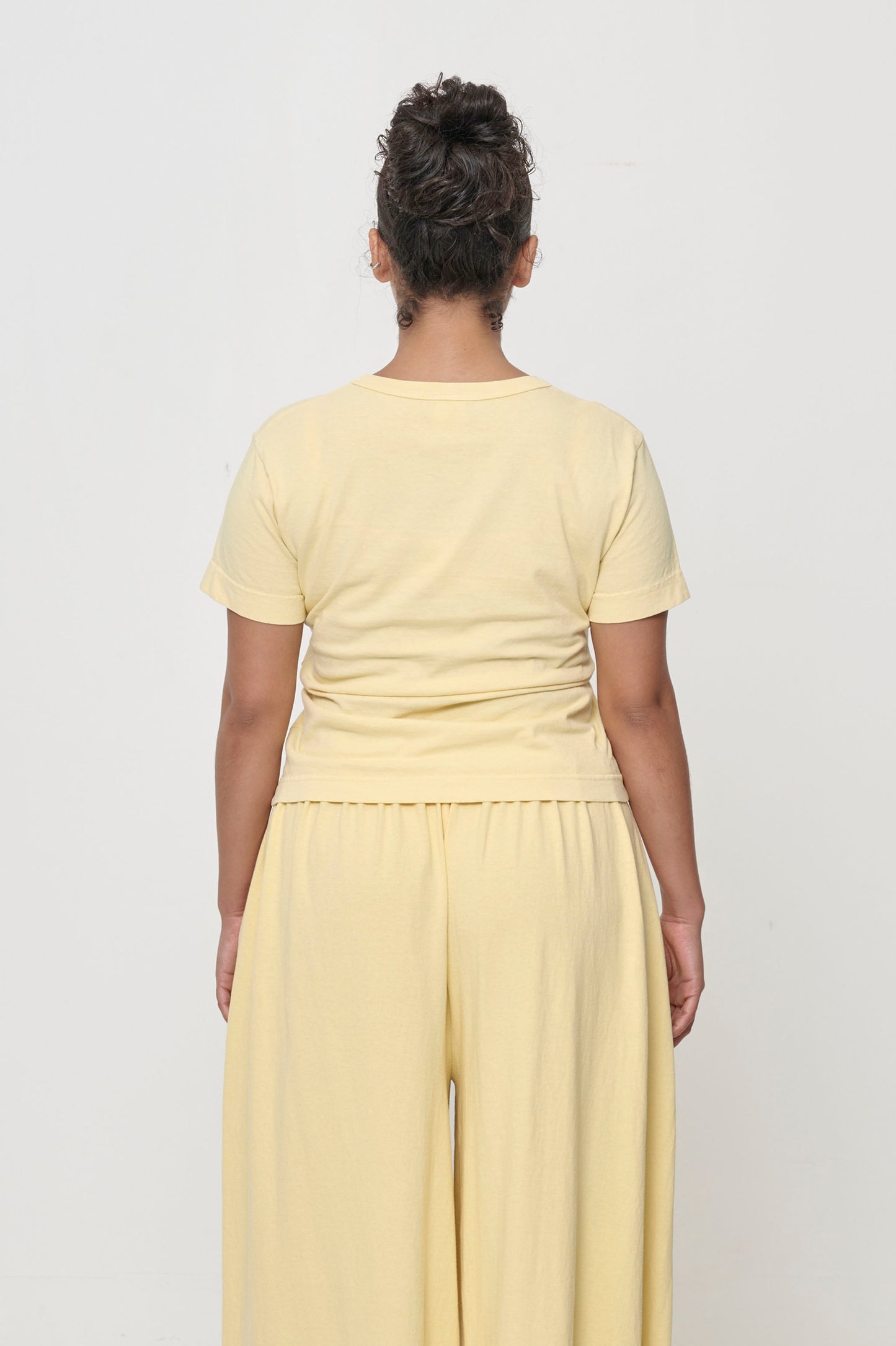 Tailored Trash Tee in French Butter, back view on a person - fitted across upper back and relaxed at middle and lower back