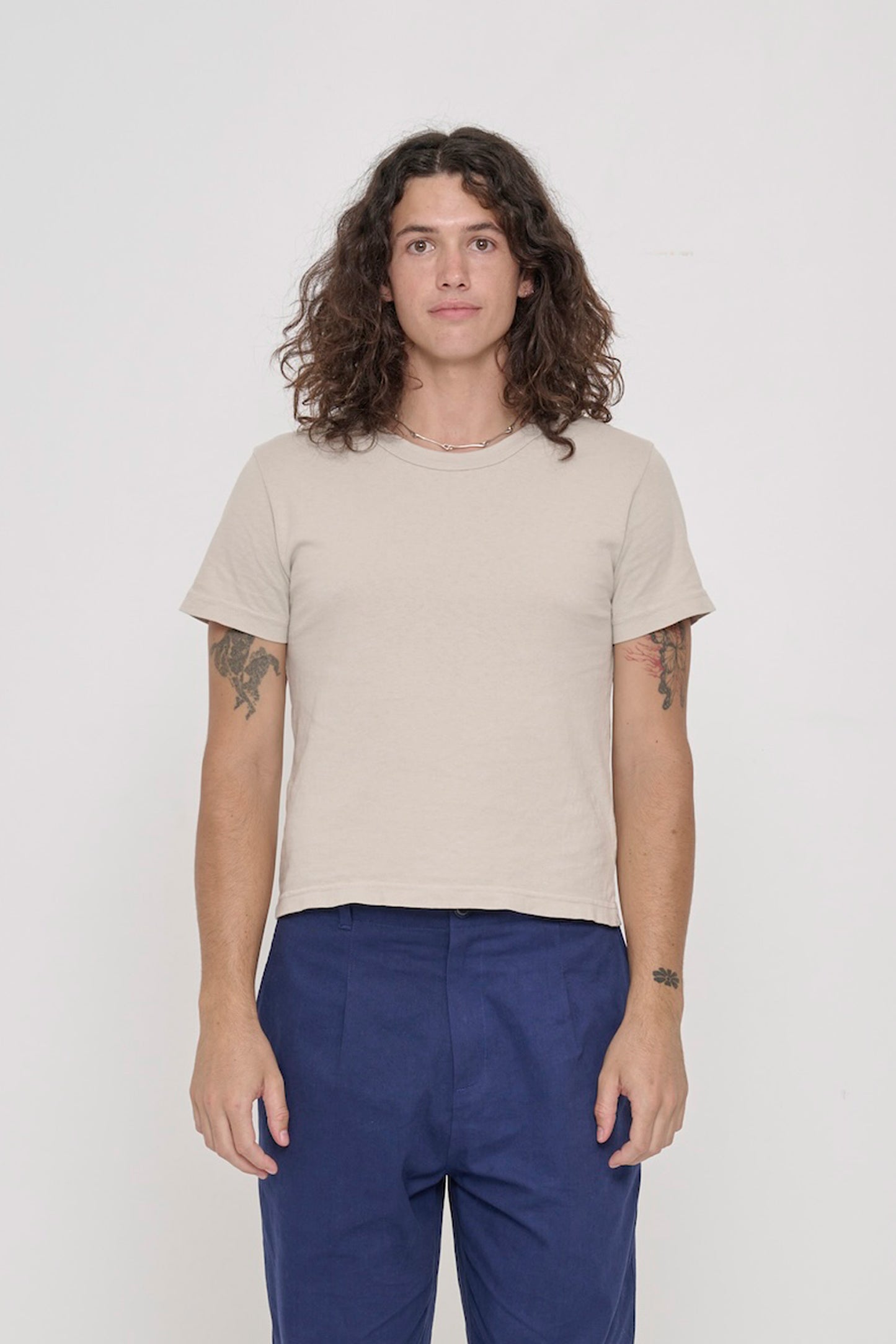6' person wearing Oat Tailored Trash Tee, shirt hem hits their upper hip.