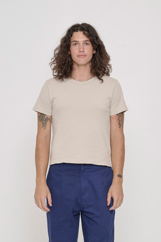 6' person wearing a size M Oat Tailored Trash Tee, shirt hem hits their upper hip.