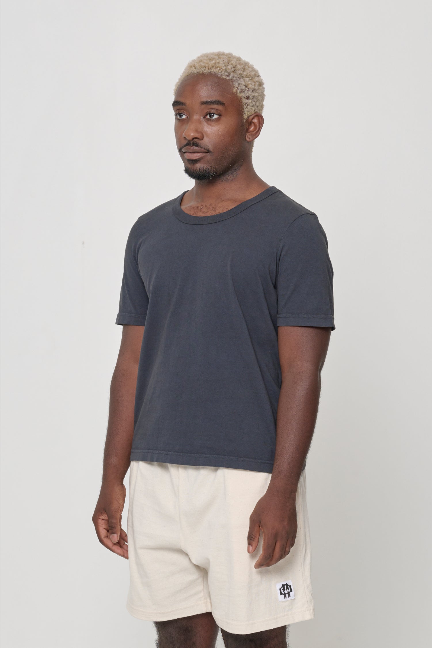 Tailored Trash Tee in White - 3/4 front view on person, showcasing slim short sleeves.