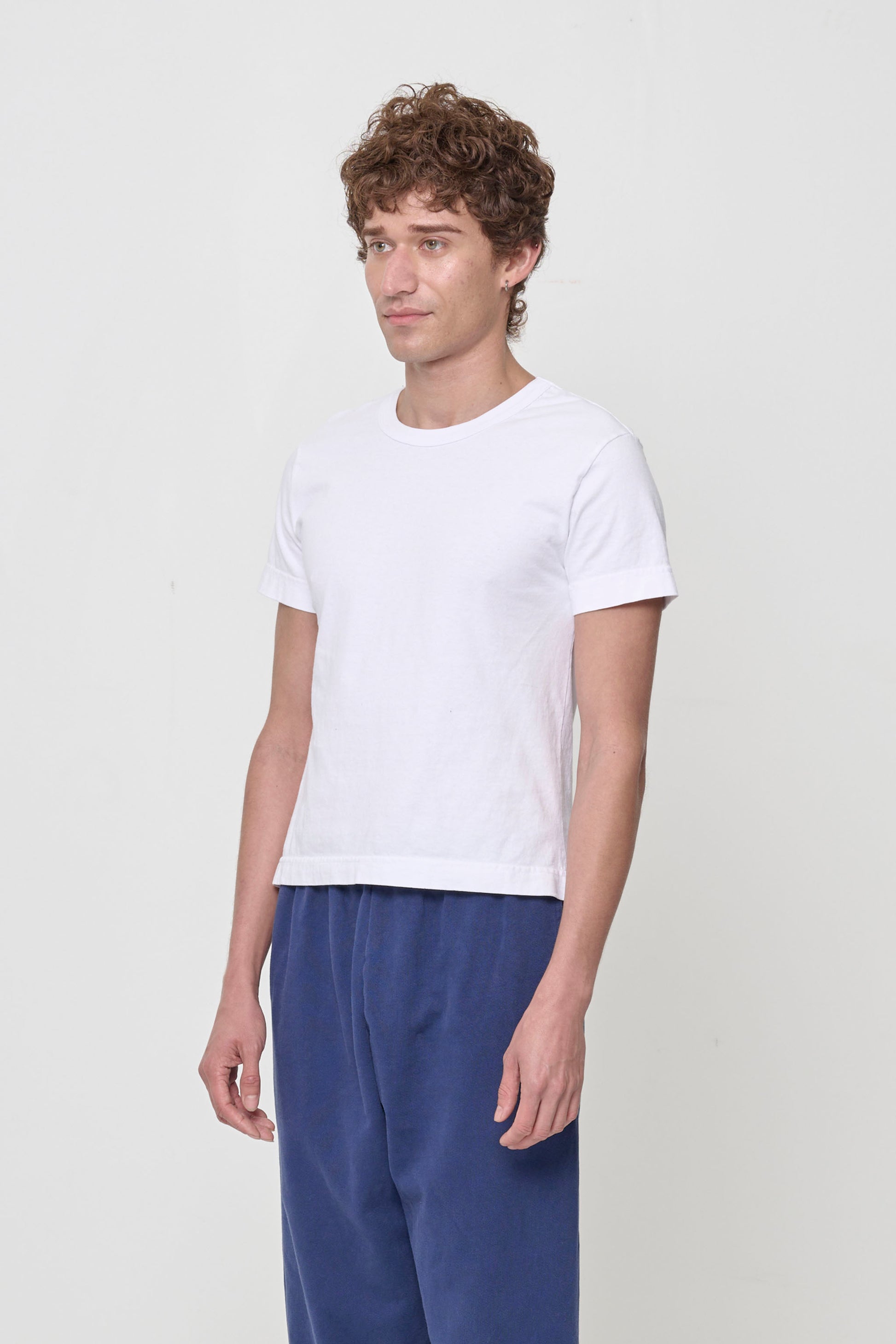 Tailored Trash Tee in White - 3/4 front view on person, showing side seams and slim short sleeves.
