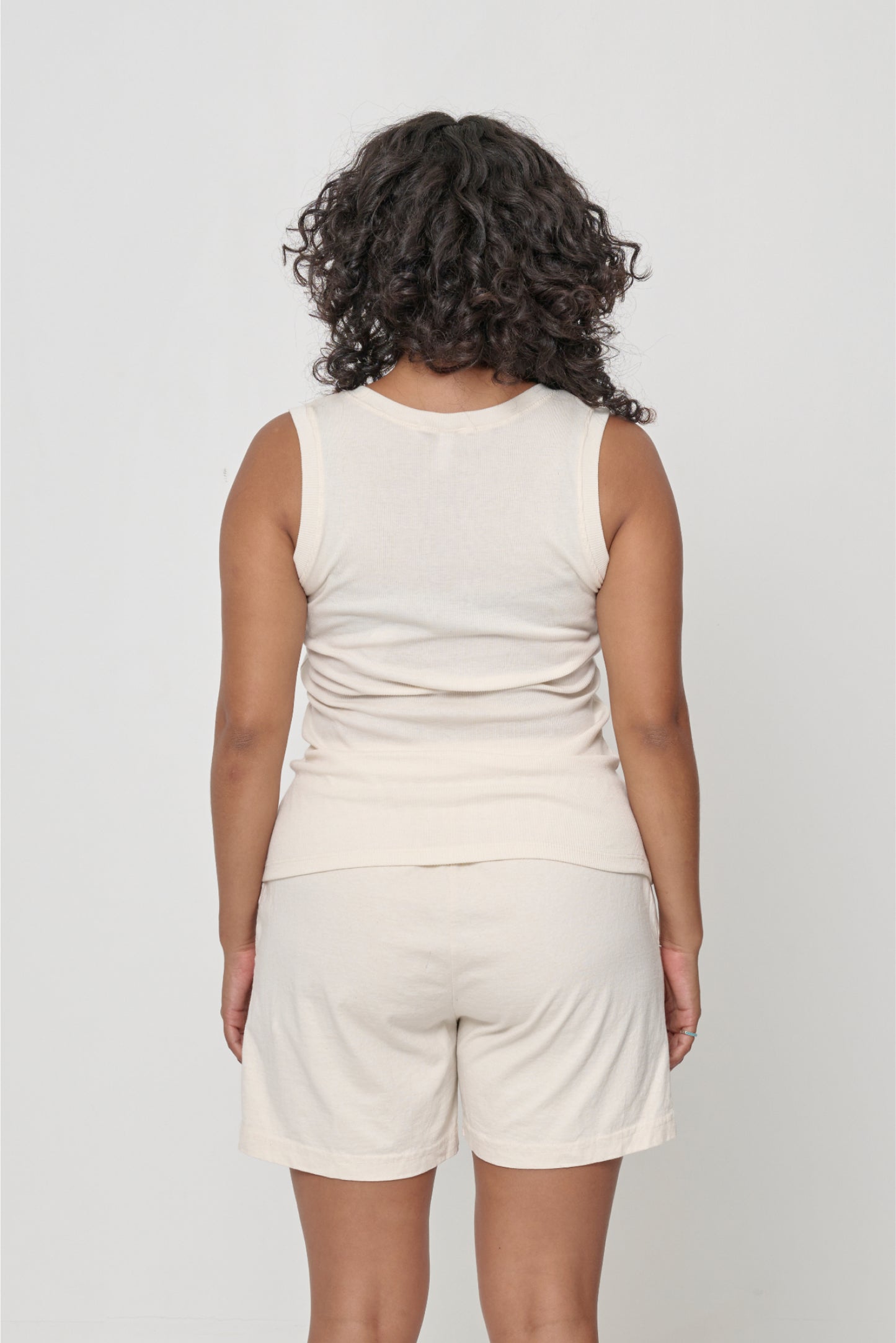 Back view: a person in a Natural The Tank, formfitting throughout.