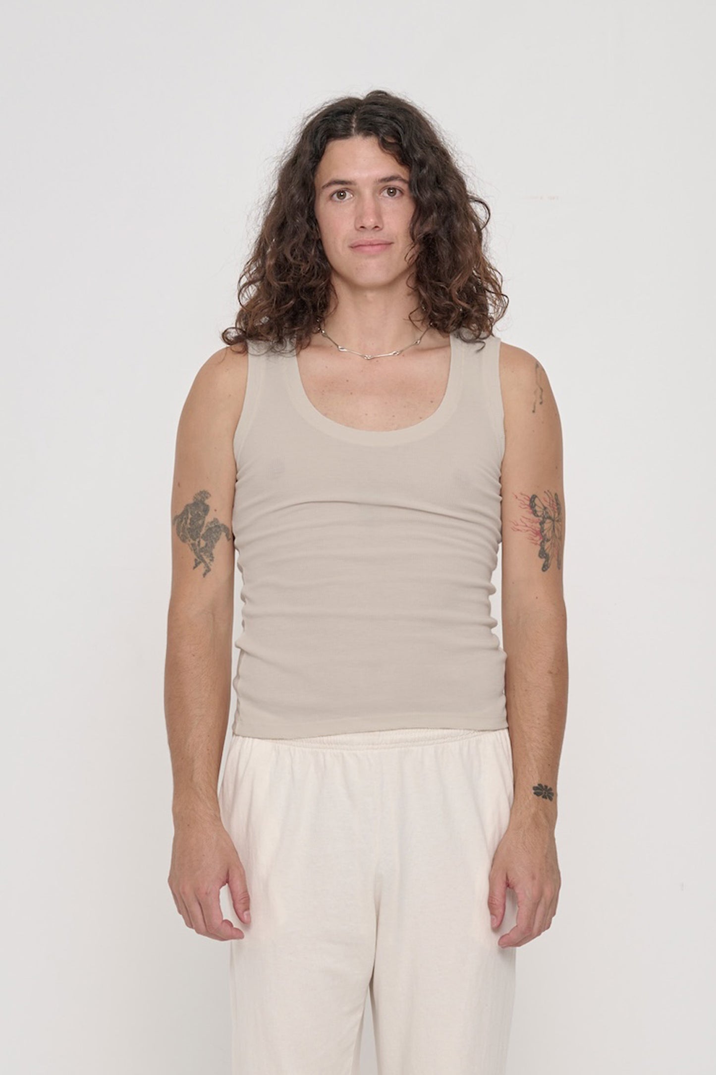 Front view of a 6' person wearing The Tank in Oat. Hem hits their high hip.
