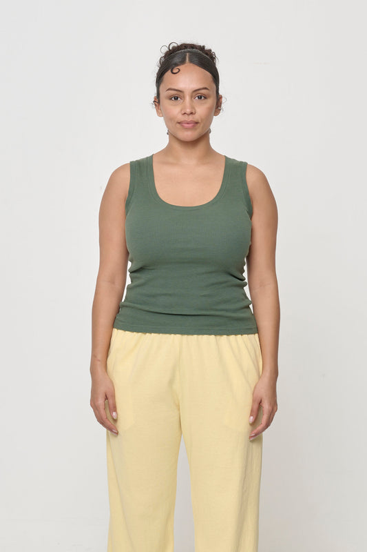 5'7" woman wearing a size S The Tank in Pine. Hem hits her upper middle hips.