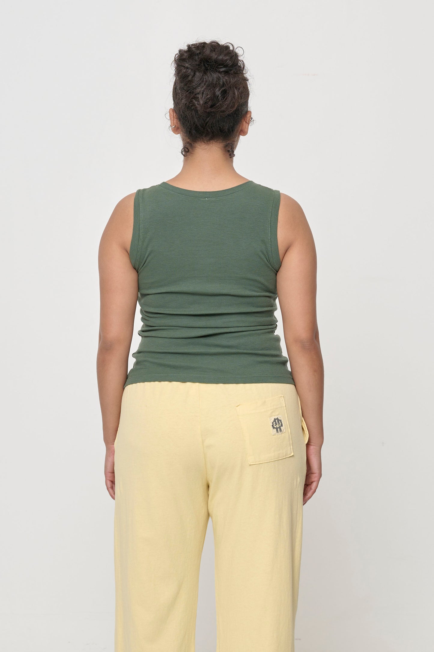 Back view: a person in a Pine The Tank, formfitting throughout.