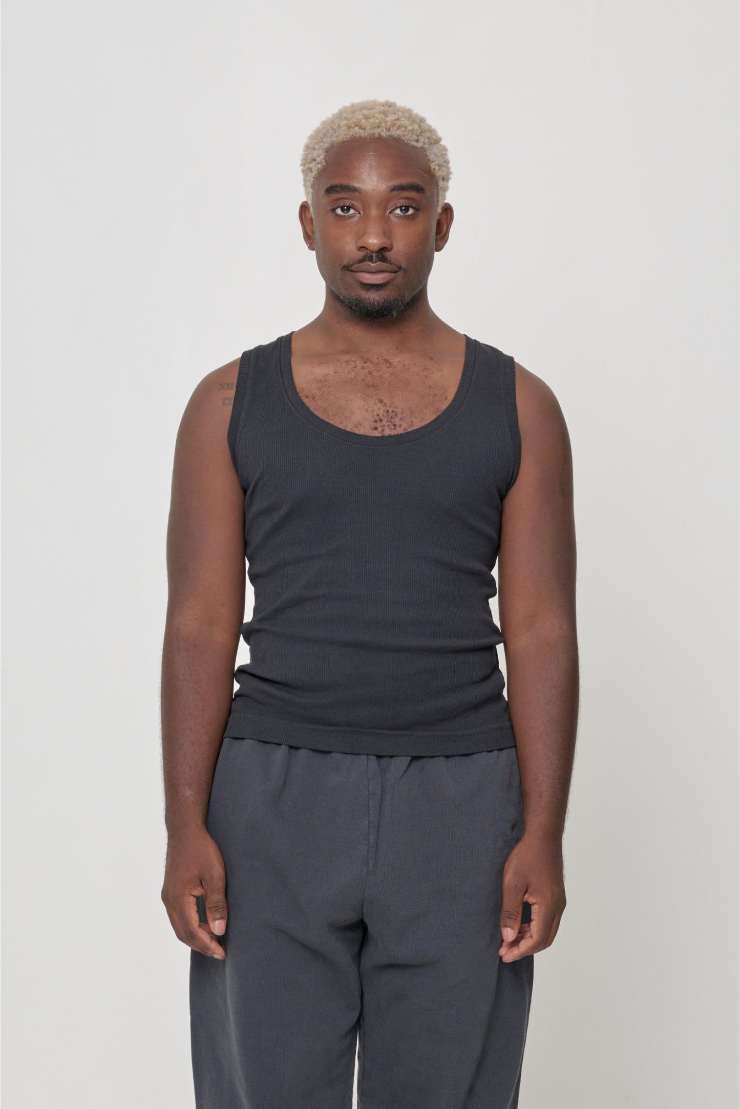 Front view of a 5'9" man wearing a size XL The Tank in Slate. Hem rests on his upper hips.
