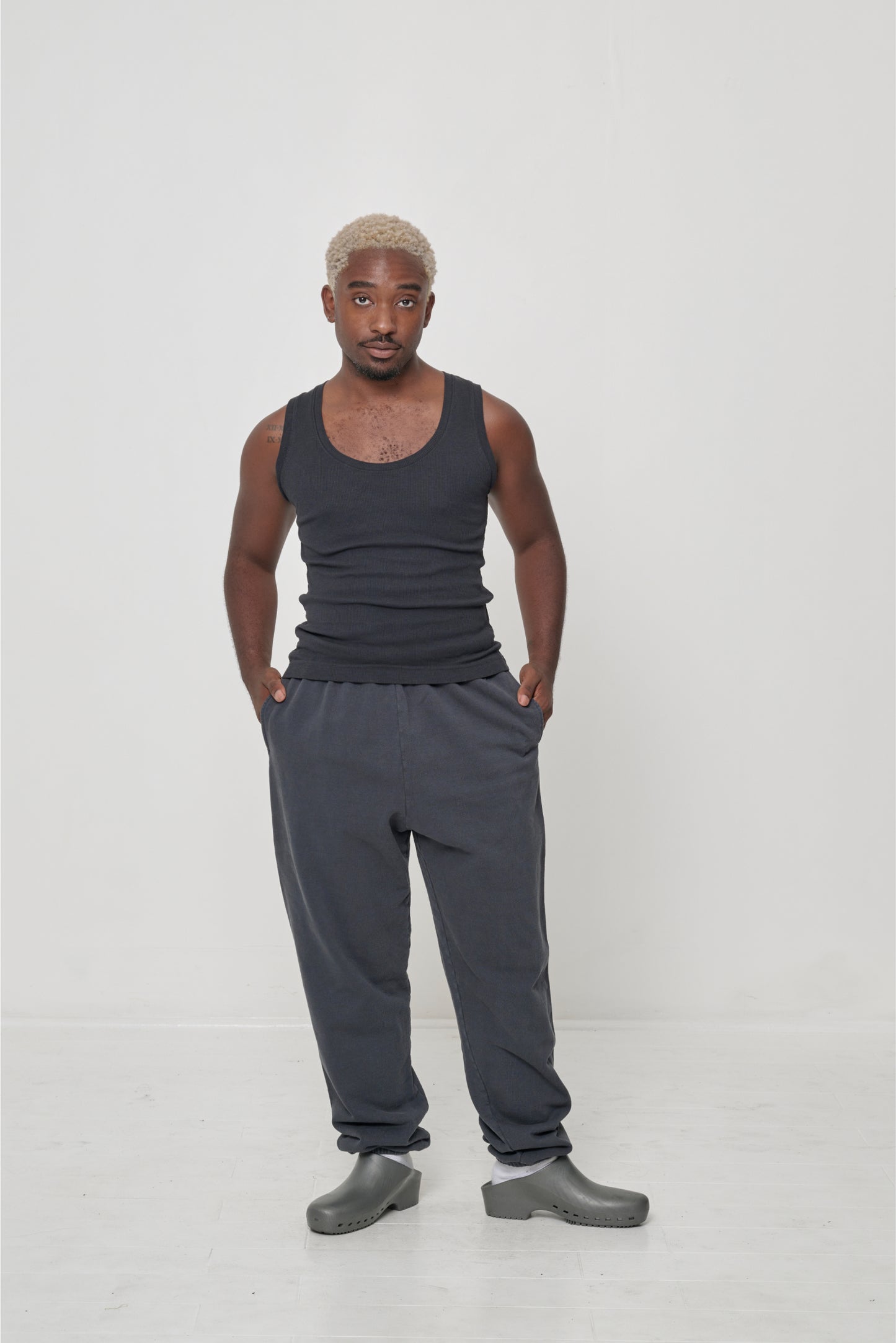 Man in Slate The Tank and Trash Sweatpants with hands in his pockets