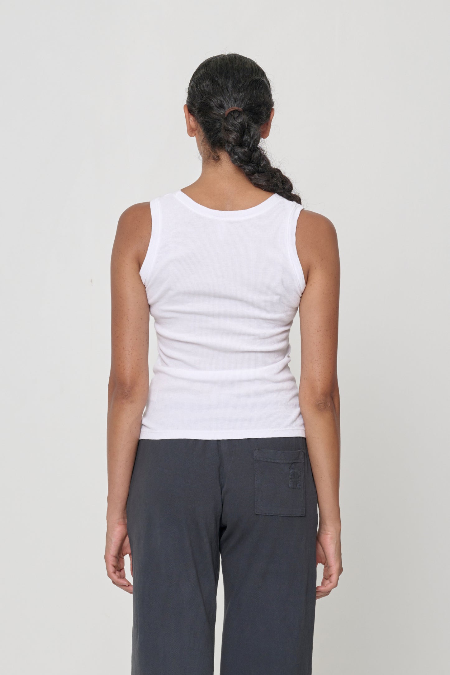 Back view: a person in a White The Tank, formfitting throughout.