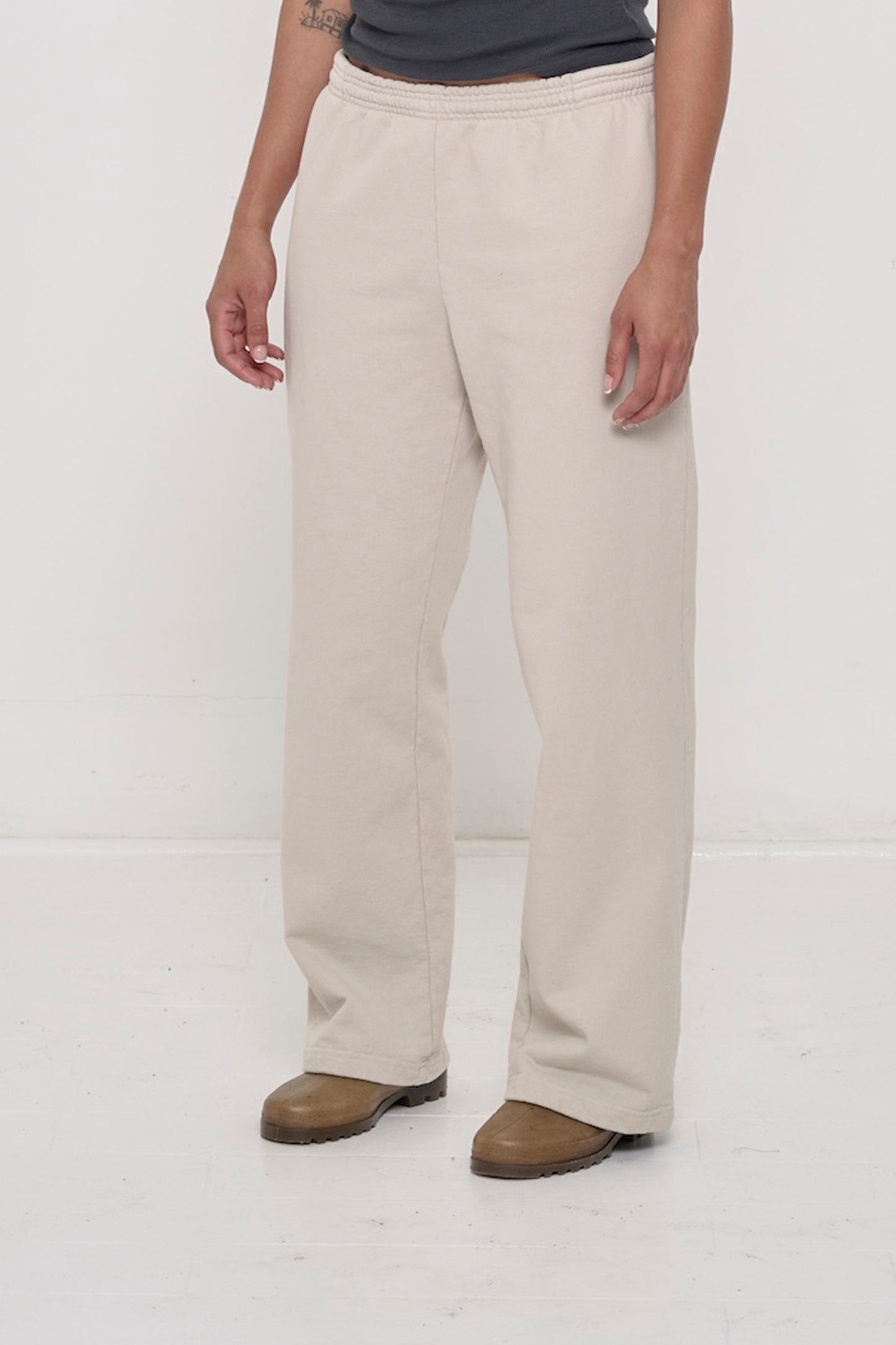 Person facing 45-degrees to the front in Oat Apartment Pants, showing inseam and outseam.