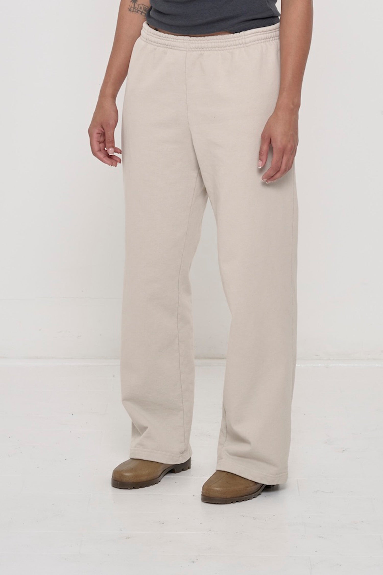 Person facing 45-degrees to the front in Oat Apartment Pants, showing inseam and outseam.