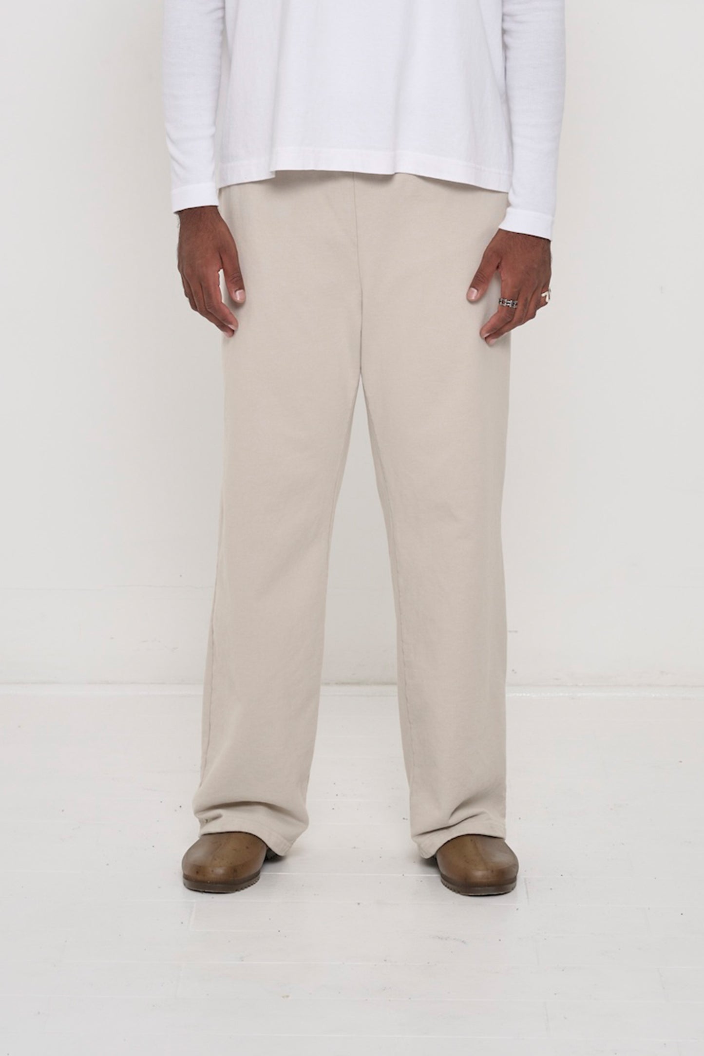 Close-up front view of a person wearing Trash Fleece Apartment Pants in Oat, showing waistband and relaxed drape.